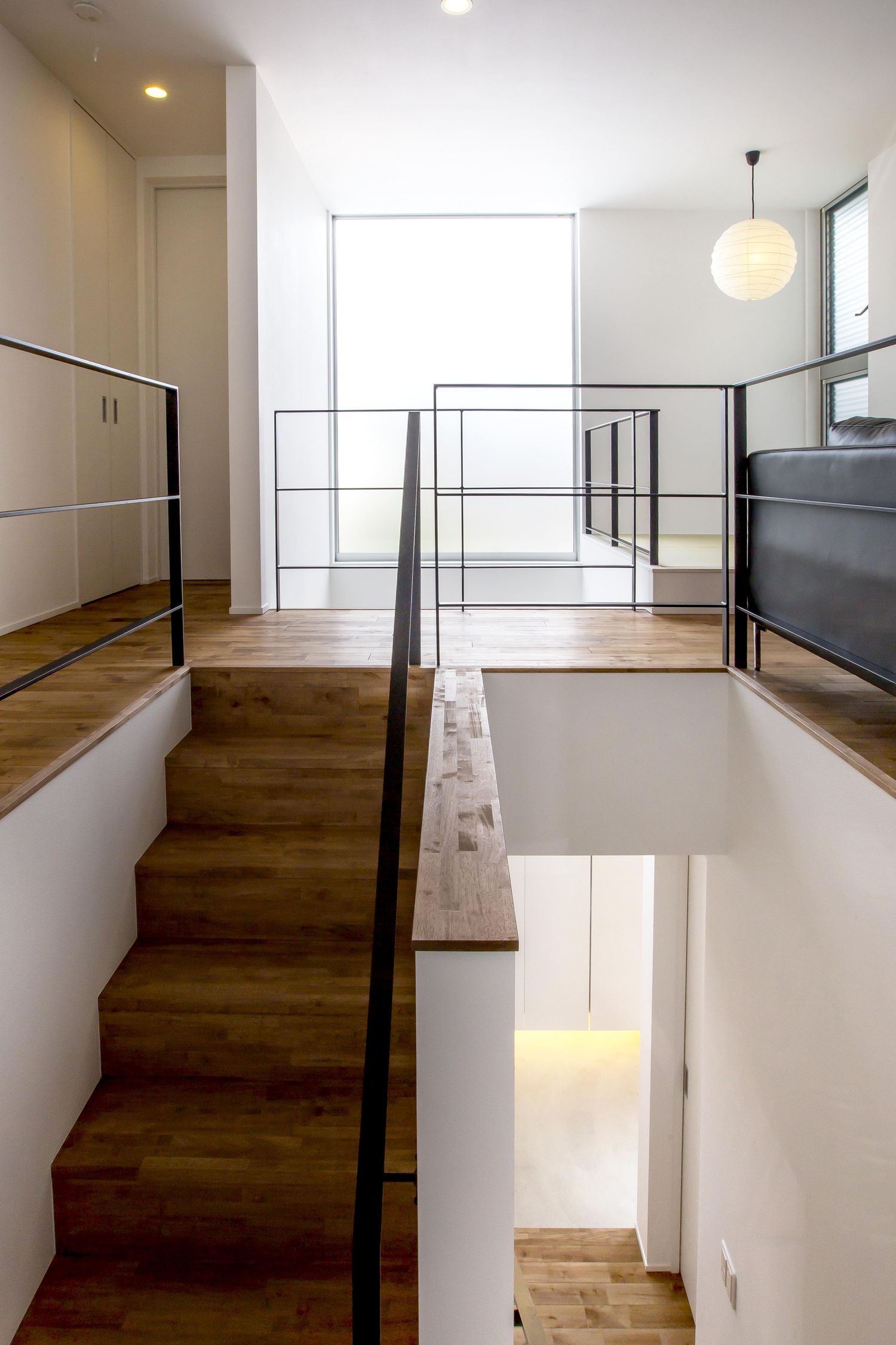 細いアイアンの手すりを取り付けた木の箱型階段・デザイン住宅