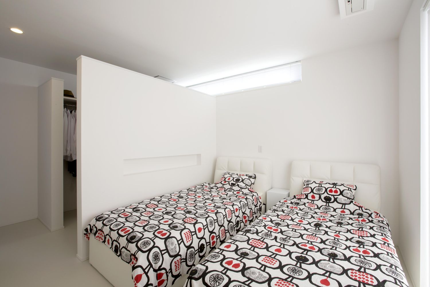 シングルベッドを二台並べたクローゼットを壁で仕切った寝室・デザイン住宅