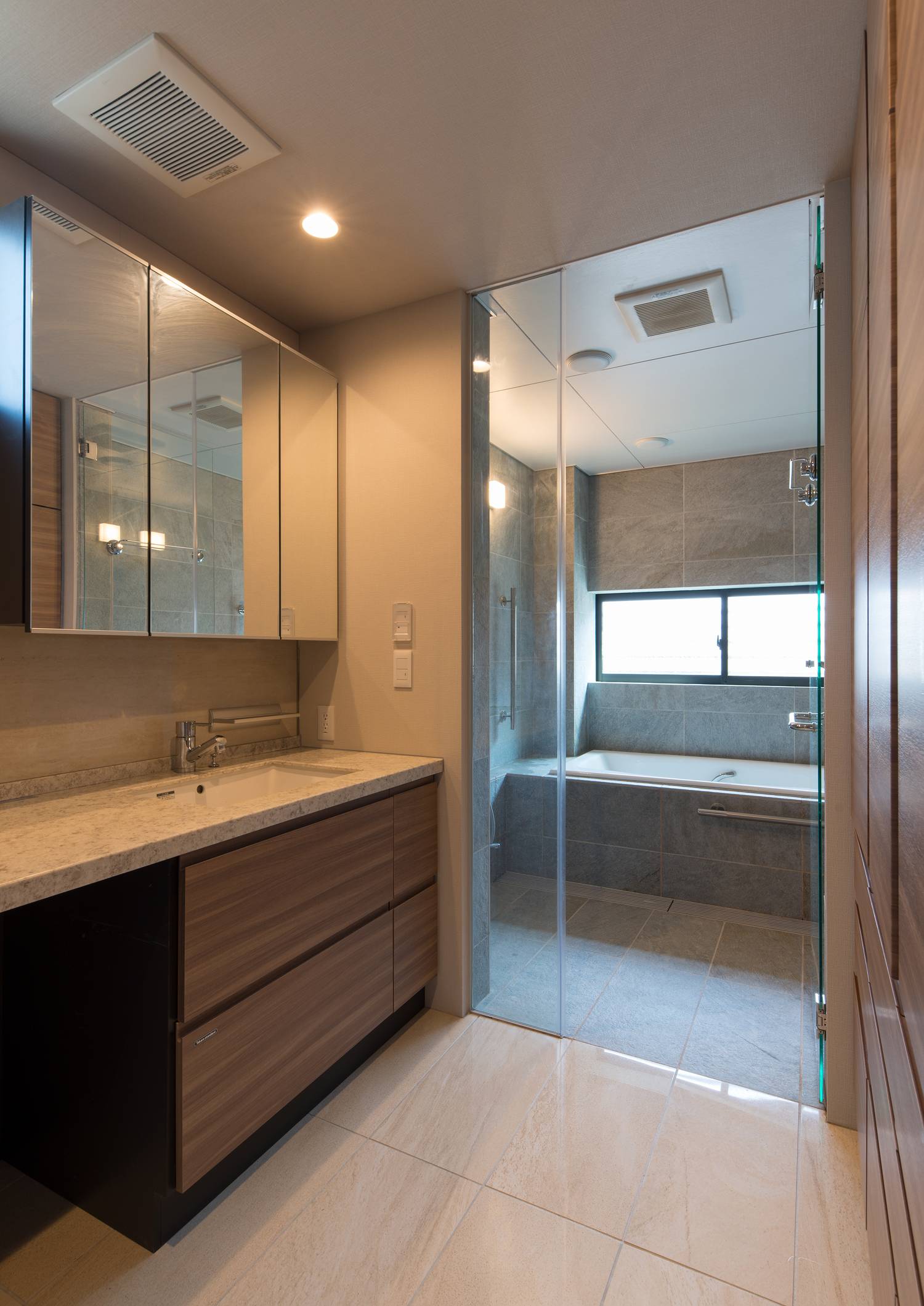 大理石の造作洗面台がある洗面所と、ガラス扉が付いた浴室・デザイン住宅 注文住宅・デザイン住宅建築実例_『CASE606 CEDAR BOX』_浴室・洗面所