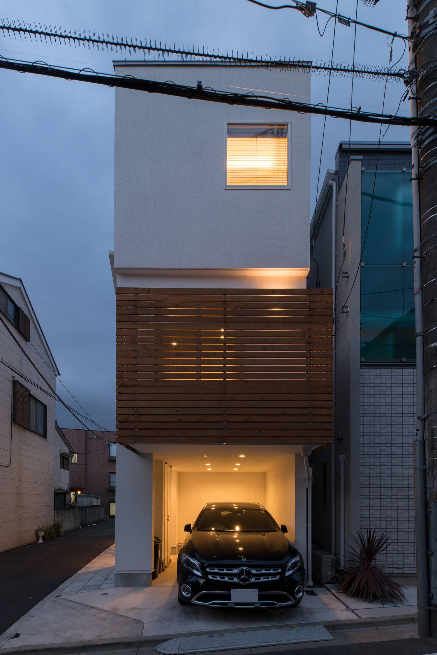 インナーガレージに照明が取り付けられた、縦長の三階建て住宅・デザイン住宅 注文住宅・デザイン住宅建築実例_『CASE628 つみ木』_外観