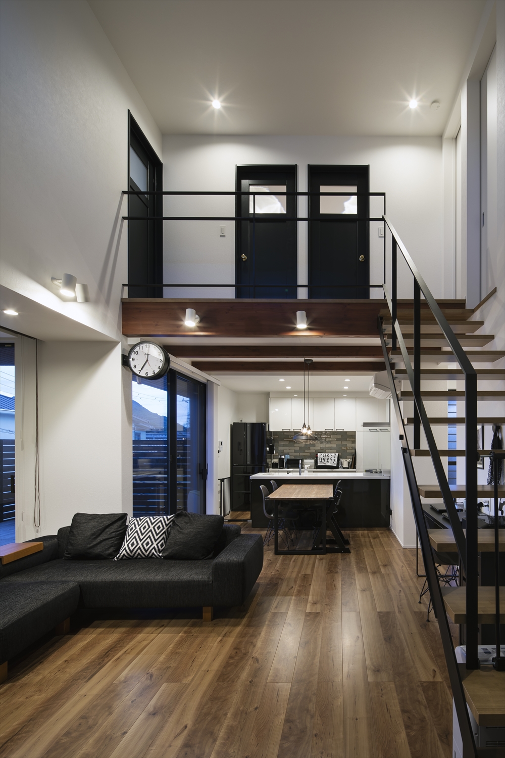 天井に取り付けられたダウンライトや壁に取り付けられたスポットライトに照らされる吹き抜けのLDK・デザイン住宅 注文住宅・デザイン住宅建築実例_『CASE629 Con』_LDK