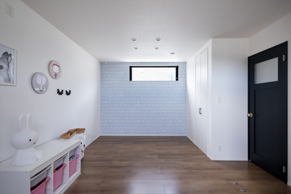 水色のアクセントクロスにハイサイドライトを設けた、窓付きの扉がある部屋・デザイン住宅 注文住宅・デザイン住宅建築実例_『CASE629 Con』_子供部屋