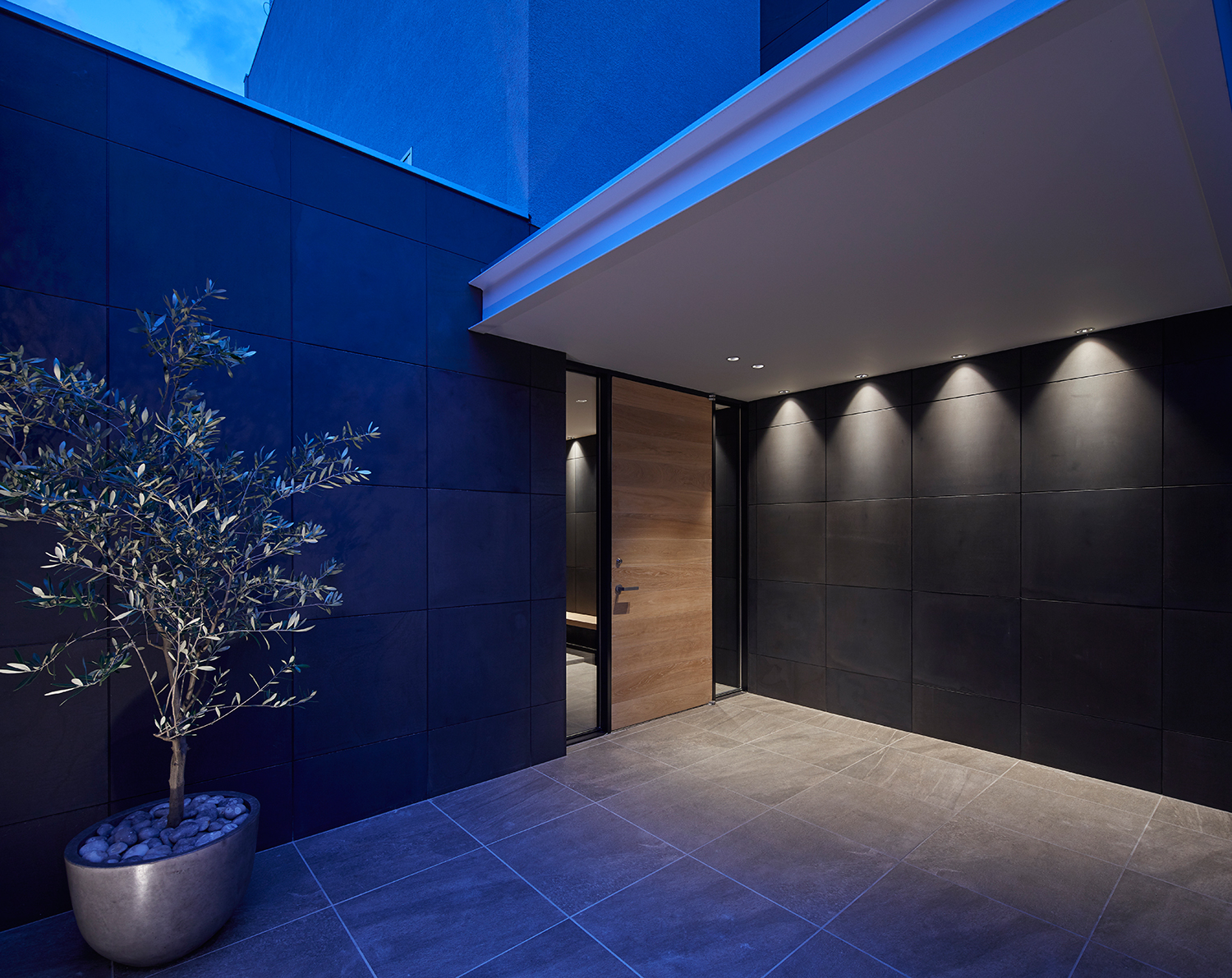 天井の壁際にダウンライトを取り付けた木の玄関扉があるエントランス・デザイン住宅 注文住宅・デザイン住宅建築実例_『CASE632 H邸(社長の邸宅)』_外観