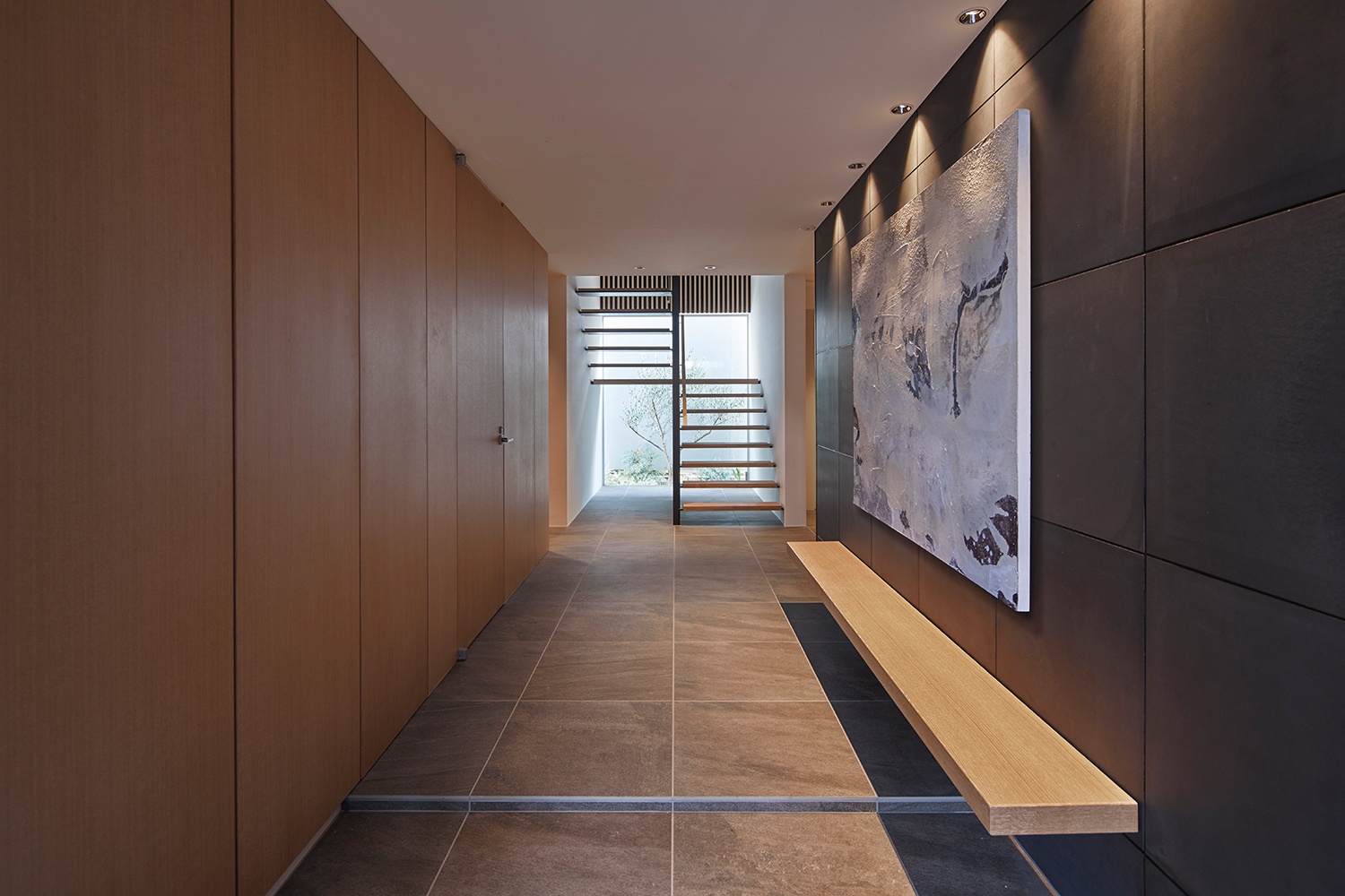 壁に木製のベンチが取り付けられた正面に窓とスケルトン階段がある玄関・デザイン住宅 注文住宅・デザイン住宅建築実例_『CASE632 H邸(社長の邸宅)』_玄関
