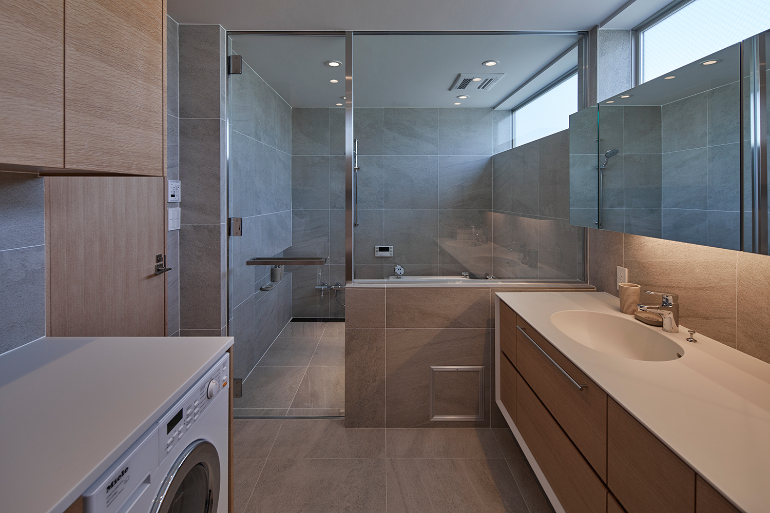 洗面所と浴室がガラスの窓とガラスの扉で仕切られている様子・デザイン住宅 注文住宅・デザイン住宅建築実例_『CASE632 H邸(社長の邸宅)』_浴室・洗面所