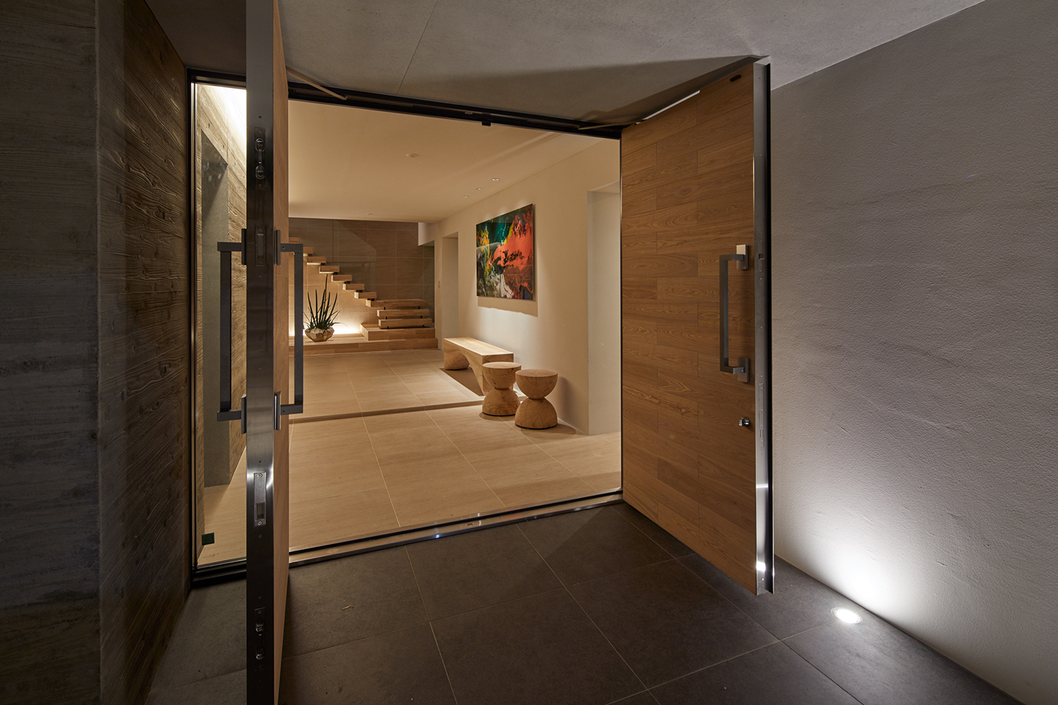 黒いタイルの床で、観音開きの扉が設けられた玄関・デザイン住宅 注文住宅・デザイン住宅建築実例_『CASE678 K邸(社長の邸宅)』_玄関