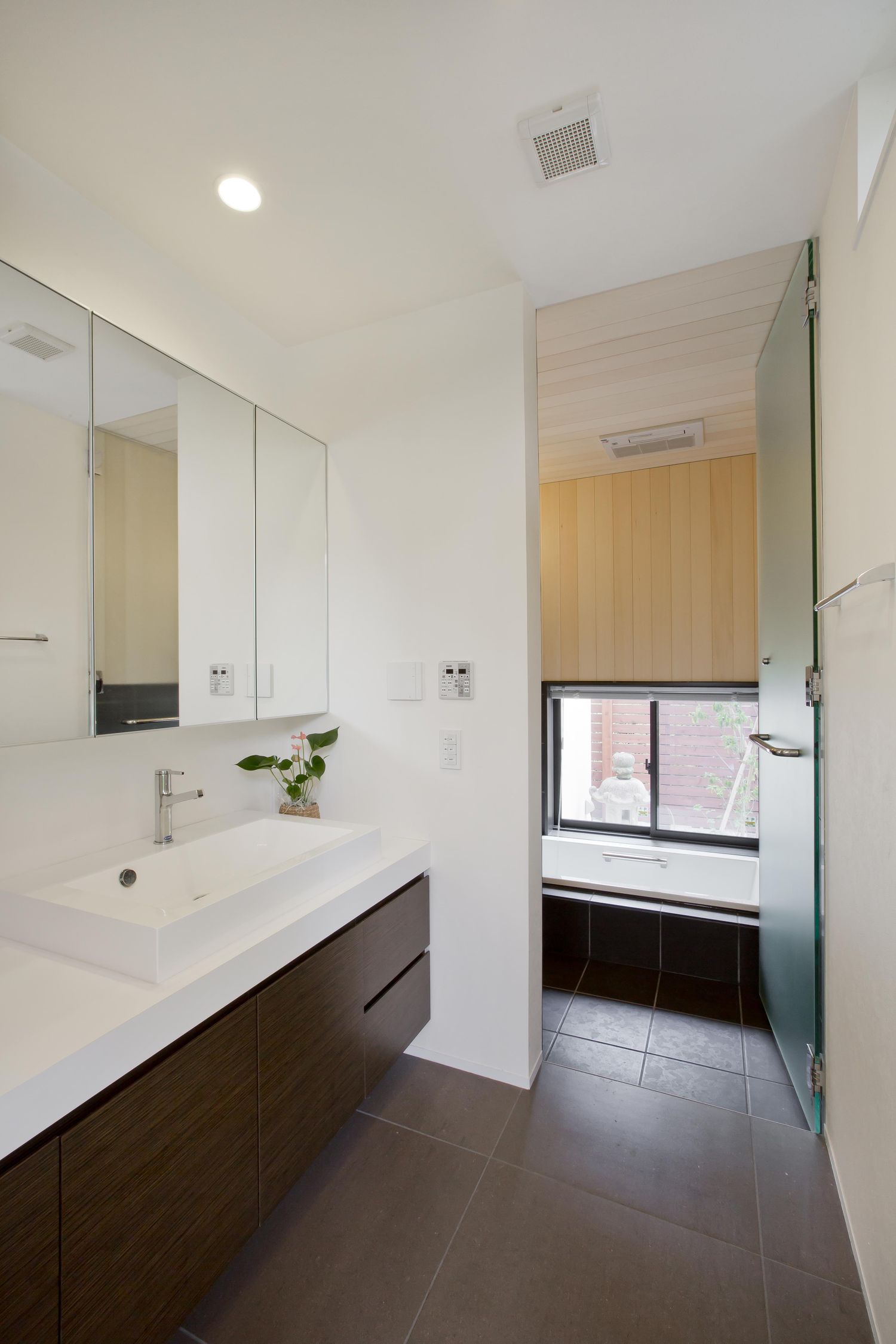 ミラーキャビネットや洗面台下の収納があるタイル床の洗面所
