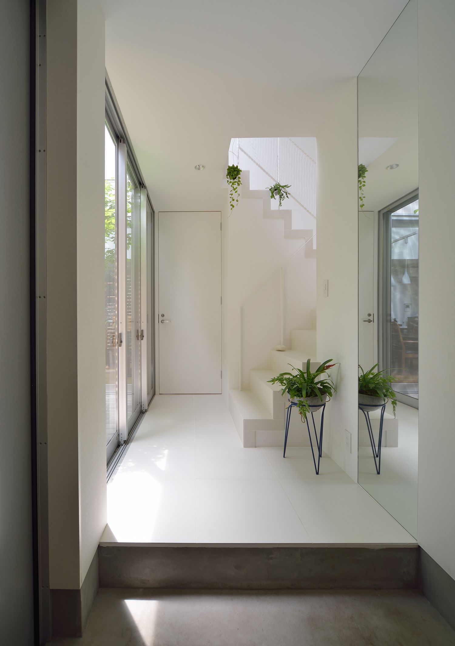 大きな窓から光が入る白でまとめた明るい玄関・デザイン住宅