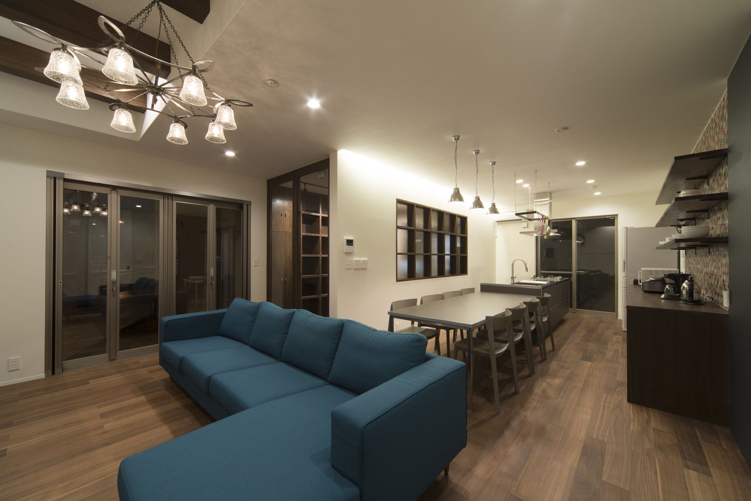 シャンデリアを取り付けL字ソファーを置いた高級感あるLDK・デザイン住宅