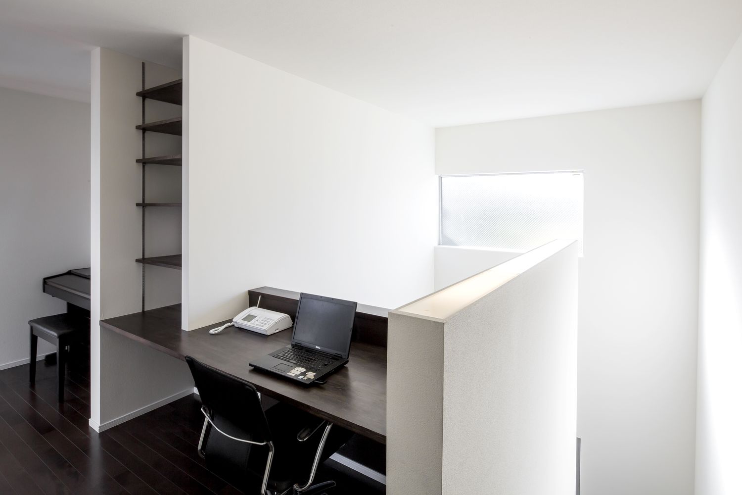 吹き抜けに面した廊下にデスクを取り付けた、オープンなワークスペース・デザイン住宅