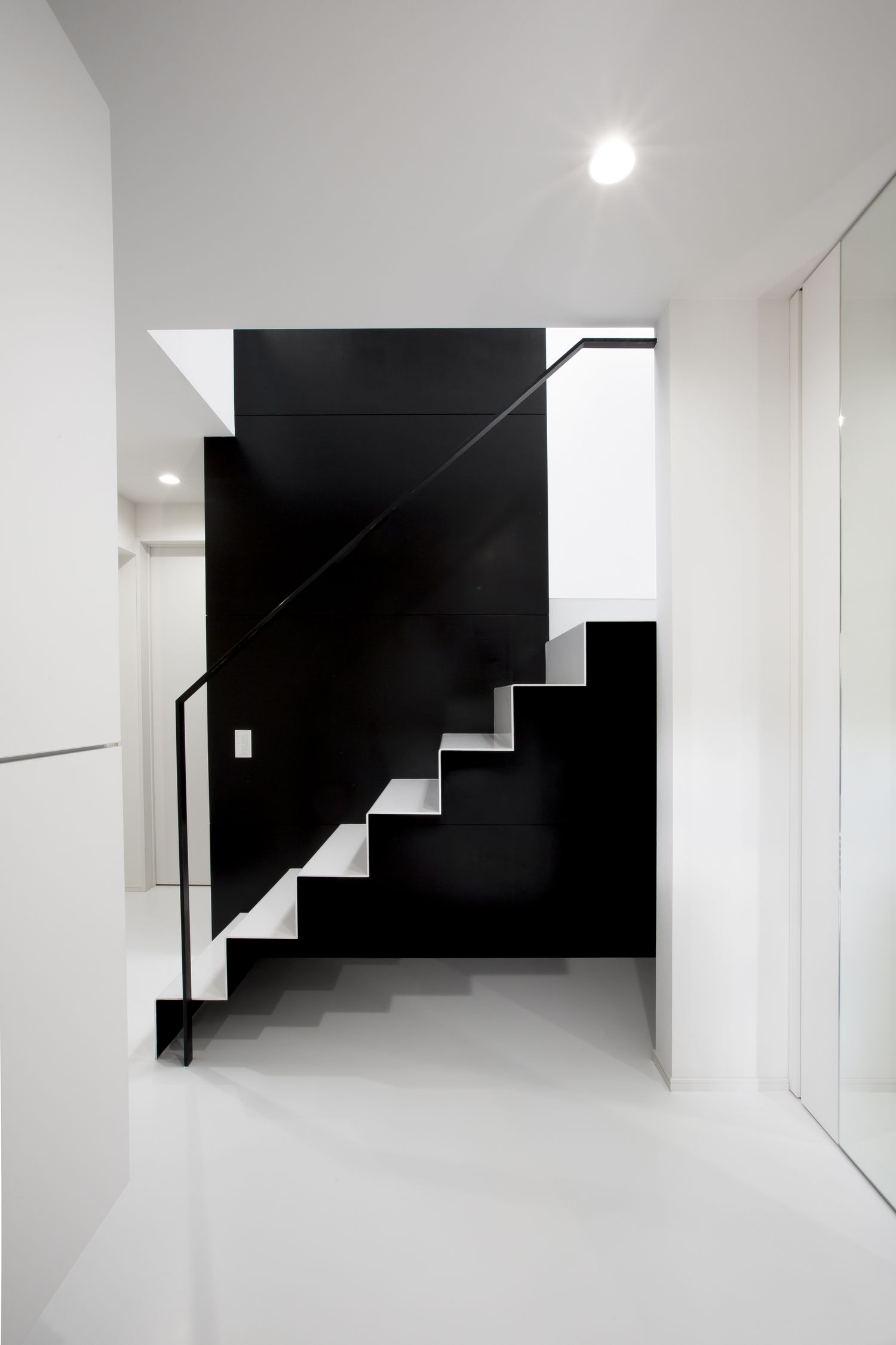 モノトーンの空間にある金属製のスケルトン階段・デザイン住宅