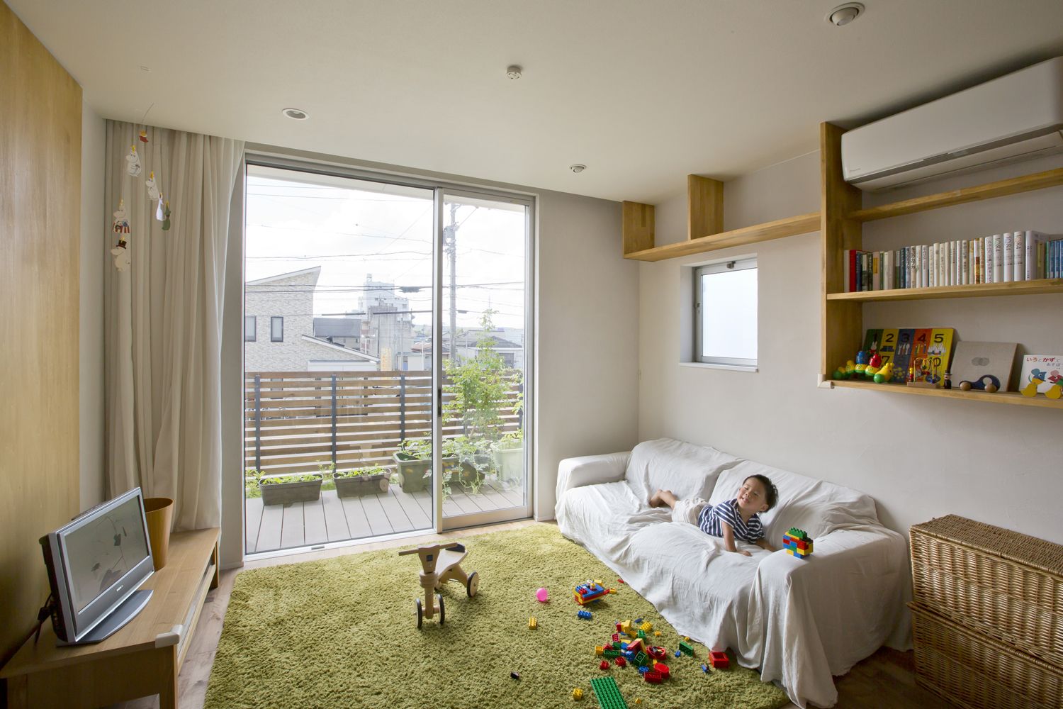 バルコニーに面した窓があるカーペットを敷いたナチュラルなLDK・デザイン住宅