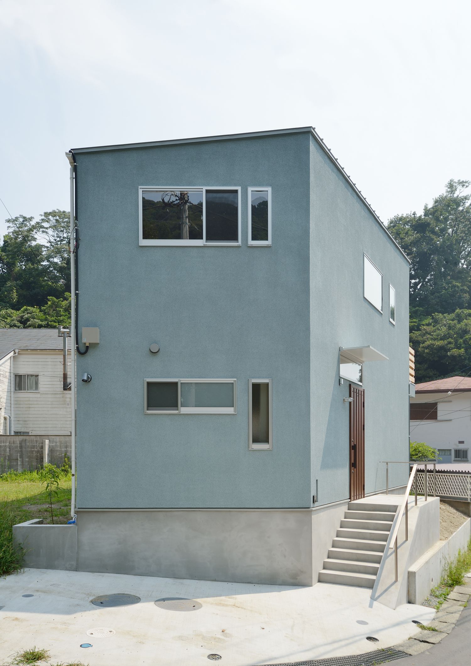 水色の外壁でシンプルなキューブ状の外観の家・デザイン住宅