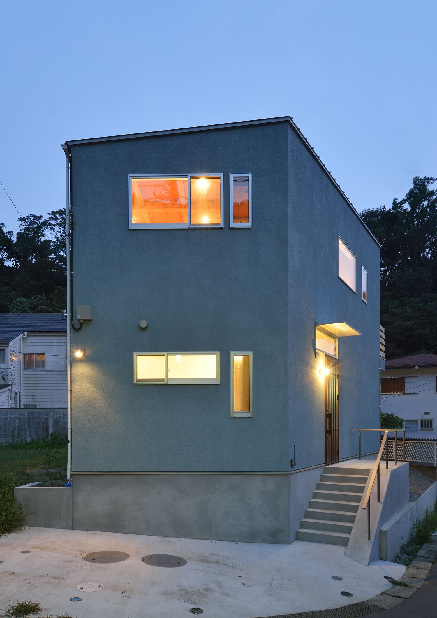 広い駐車スペースとコンクリートの階段アプローチがあるシンプルな外観・デザイン住宅