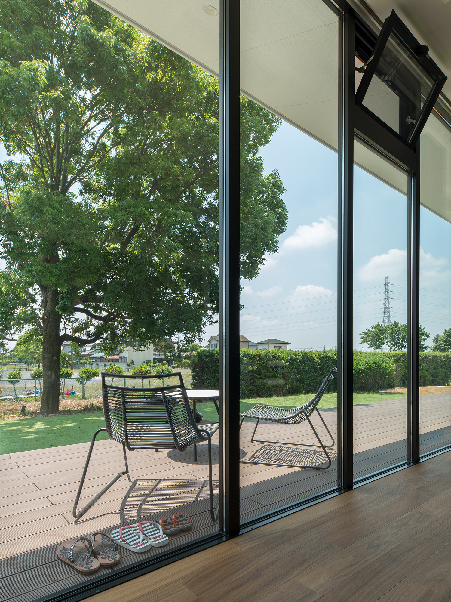 テーブルと椅子を置いたウッドデッキのテラスとフラットに繋がるLDK・デザイン住宅 注文住宅・デザイン住宅建築実例_『CASE634 アトリエを持つ家』_LDK