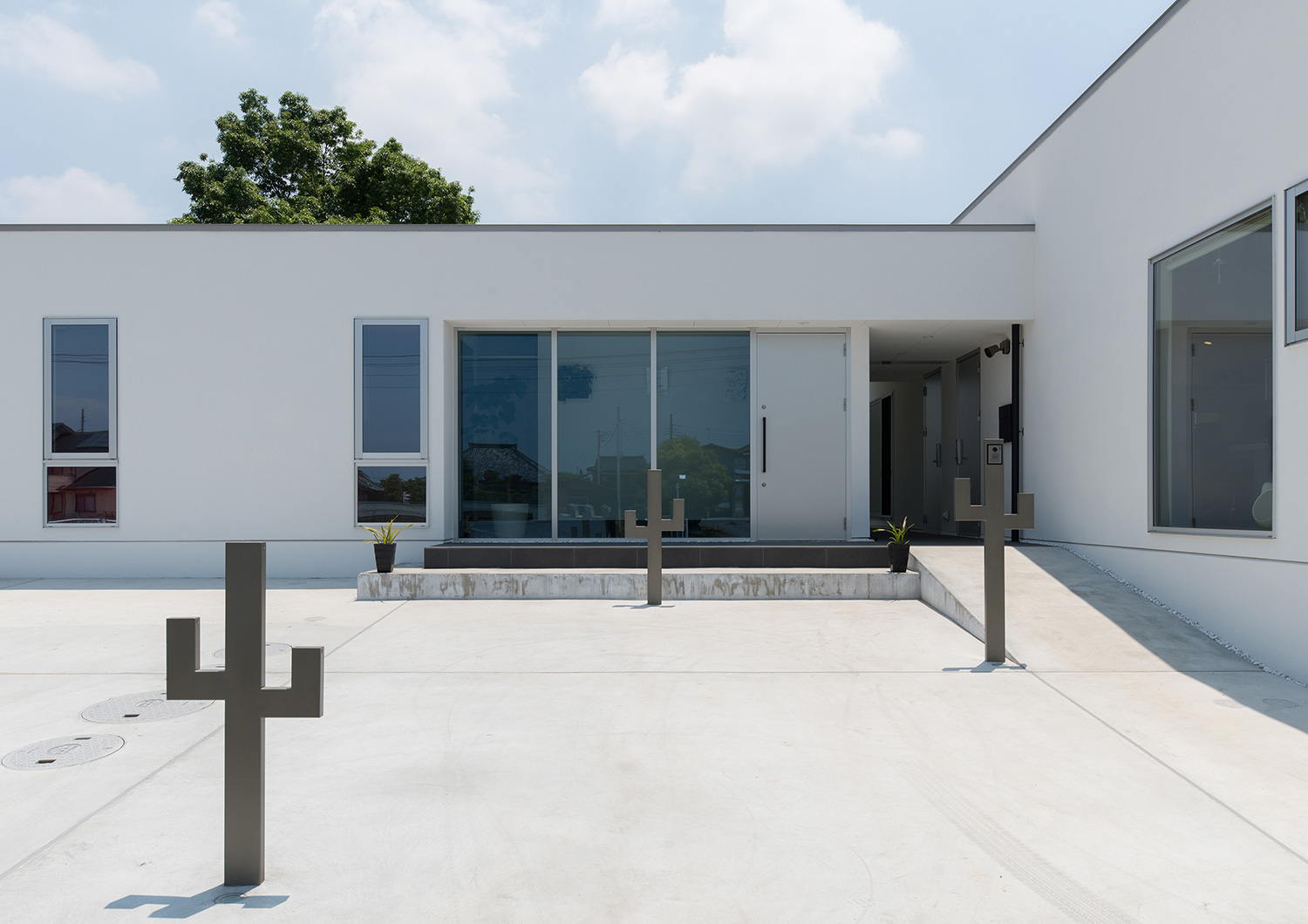サボテンのようなオブジェを置いたコンクリートのアプローチがある白い外壁の住宅・デザイン住宅 注文住宅・デザイン住宅建築実例_『CASE634 アトリエを持つ家』_外観
