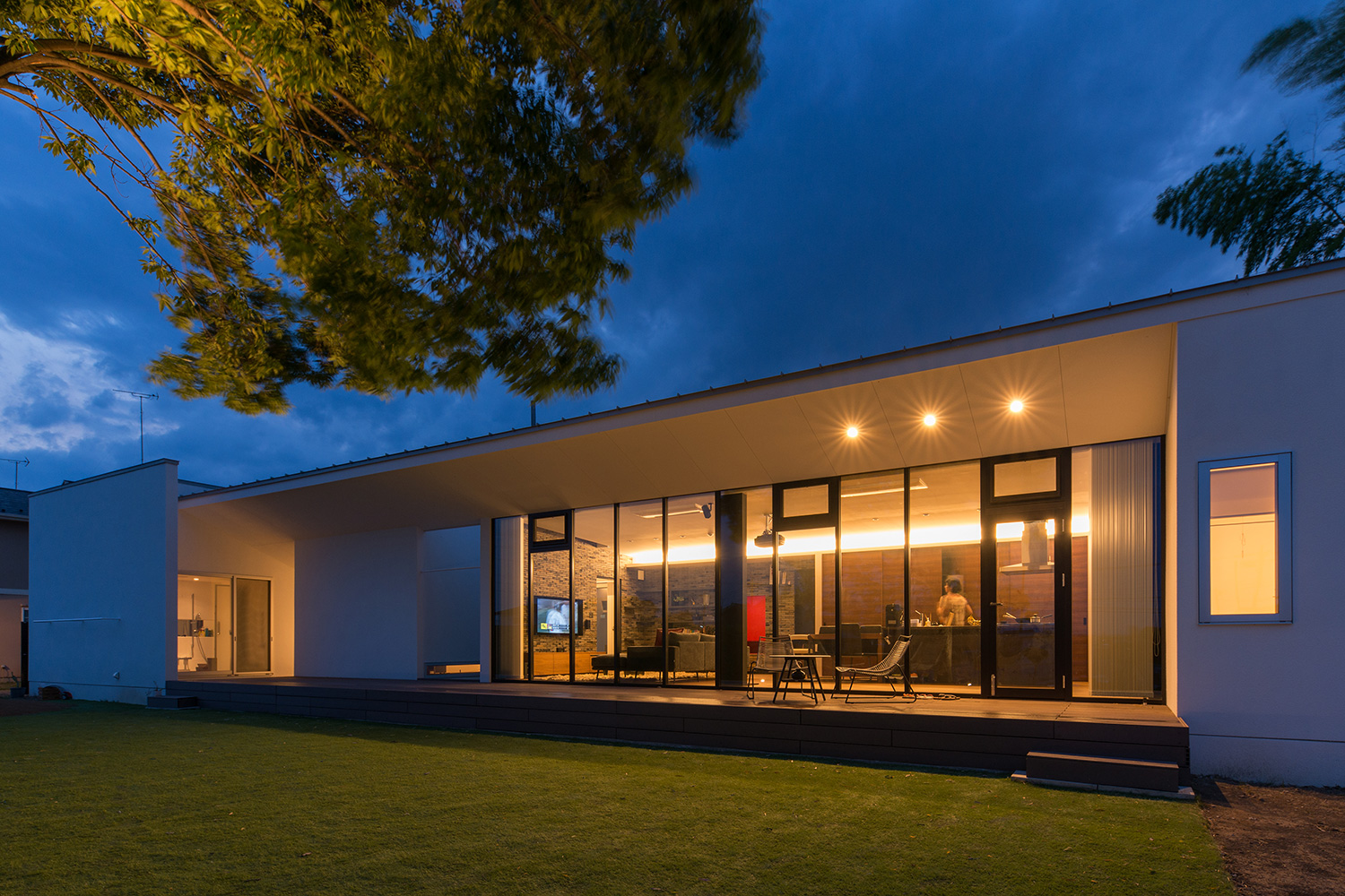 正面に芝生が広がる、ダウンライトを取り付けた軒天井付きのテラス・デザイン住宅 注文住宅・デザイン住宅建築実例_『CASE634 アトリエを持つ家』_外観