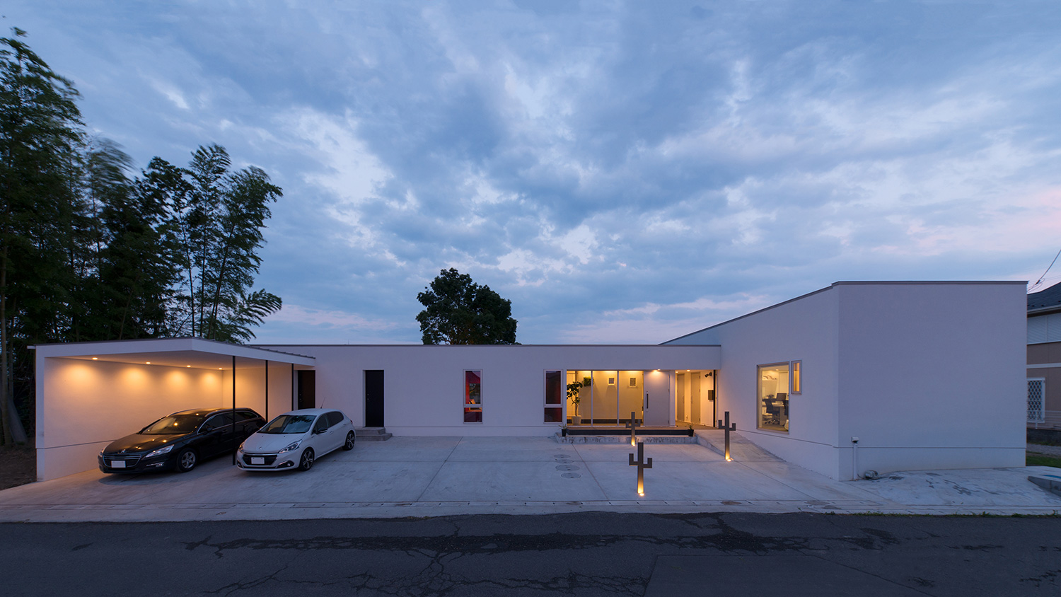 車が二台止められている、白い外壁のコの字型の平屋住宅・デザイン住宅 注文住宅・デザイン住宅建築実例_『CASE634 アトリエを持つ家』_外観