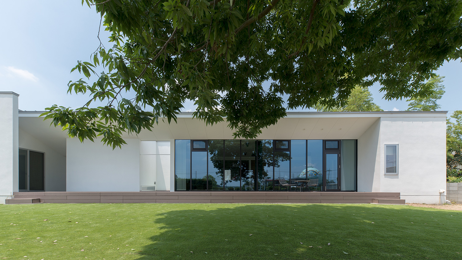テラスの正面に芝生や木がある、白い外壁の住宅・デザイン住宅 注文住宅・デザイン住宅建築実例_『CASE634 アトリエを持つ家』_外観