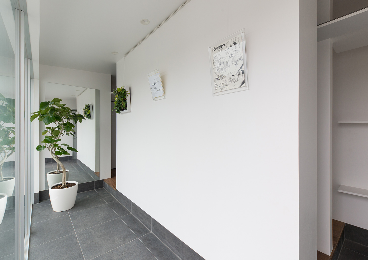 シューズインクローゼットと繋がる、観葉植物が置かれたグレーのタイルの玄関・デザイン住宅 注文住宅・デザイン住宅建築実例_『CASE634 アトリエを持つ家』_玄関