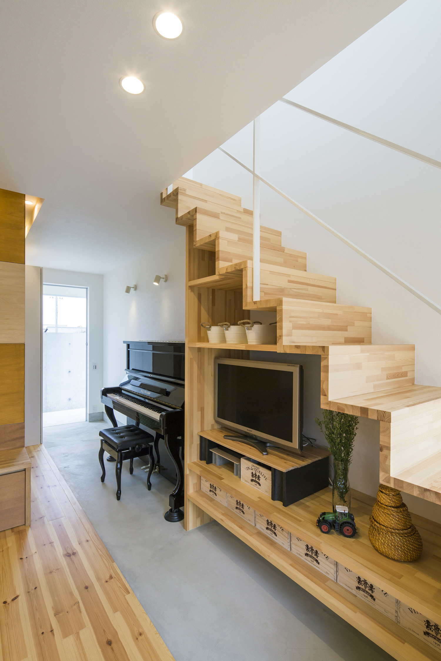 スケルトン階段下のスペースに、階段と同じ木材で棚を作りテレビなどを置いたLDK・デザイン住宅 注文住宅・デザイン住宅建築実例_『CASE636 cube+』_階段
