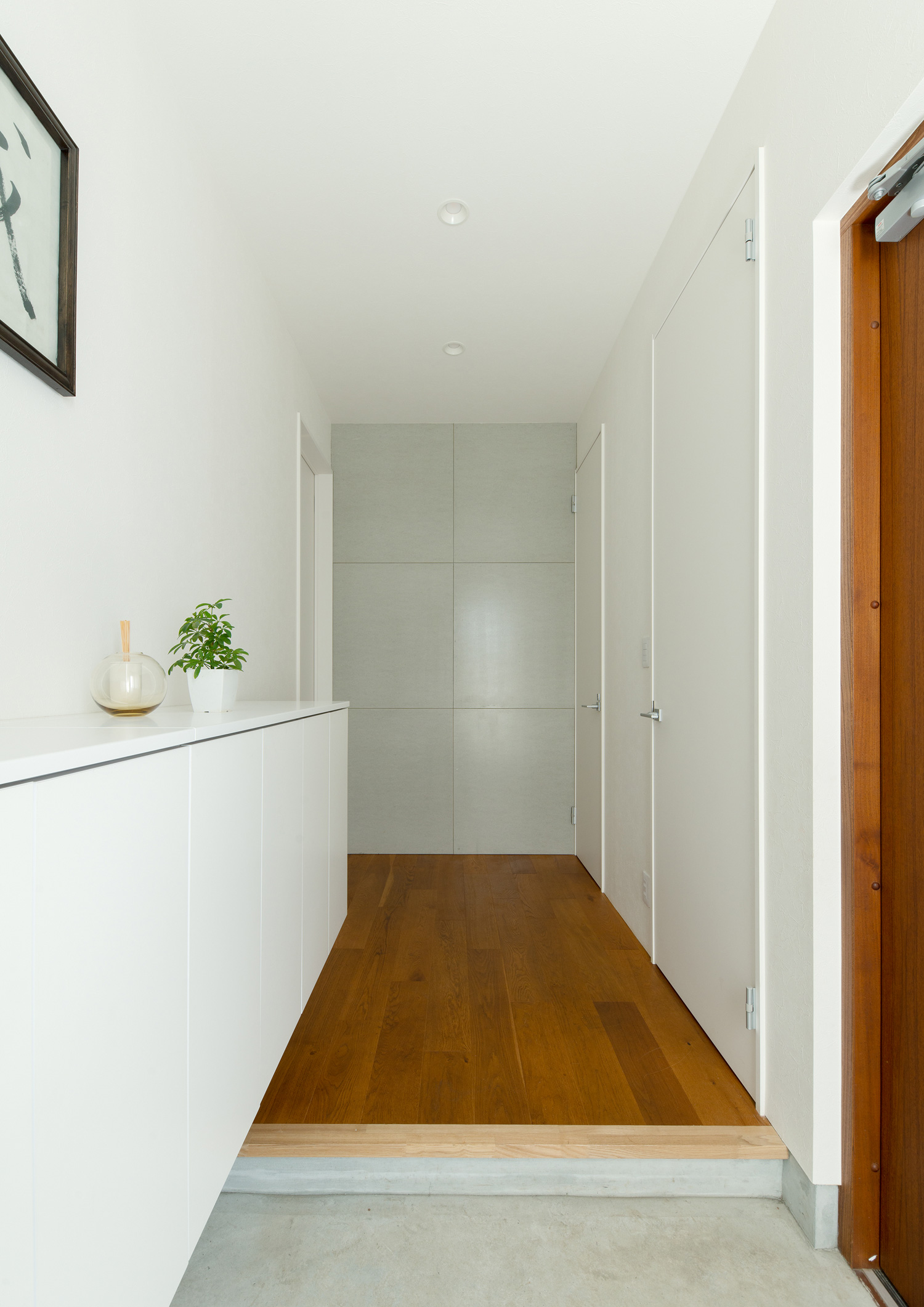 モルタルの玄関から白い壁でフローリングの廊下が見える様子・デザイン住宅 注文住宅・デザイン住宅建築実例_『CASE637 『Assemble』』_玄関