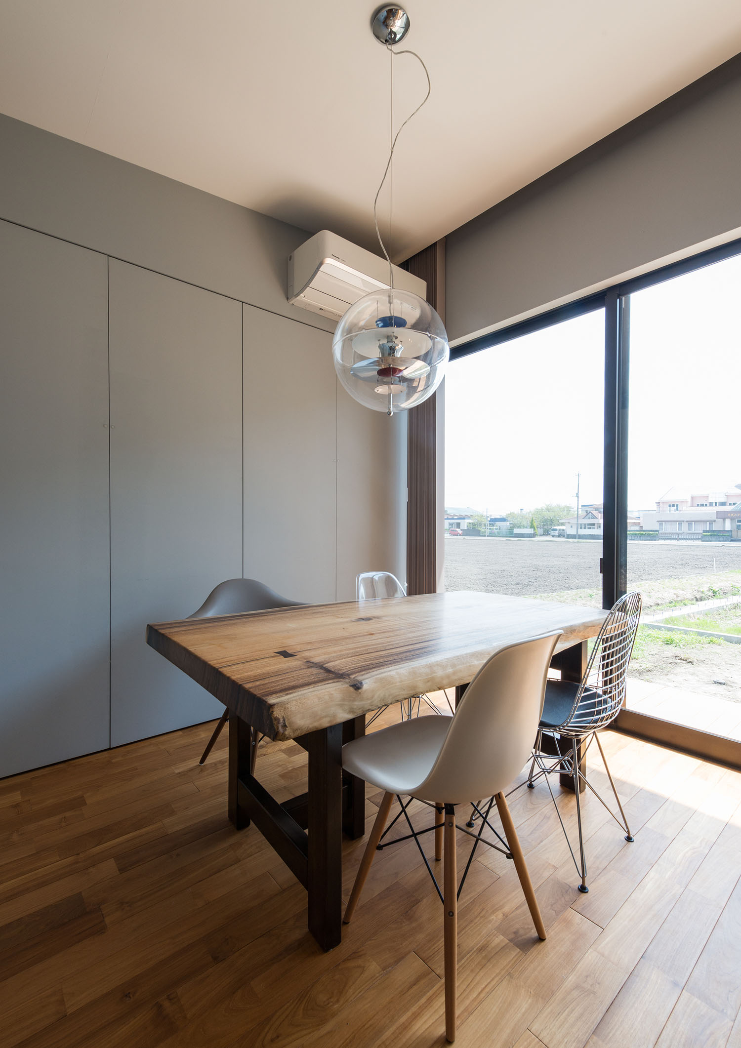 ペンダントライトが上にある一枚板のダイニングテーブルから外の景色が見える様子・デザイン住宅 注文住宅・デザイン住宅建築実例_『CASE631 こやのいえ』_LDK