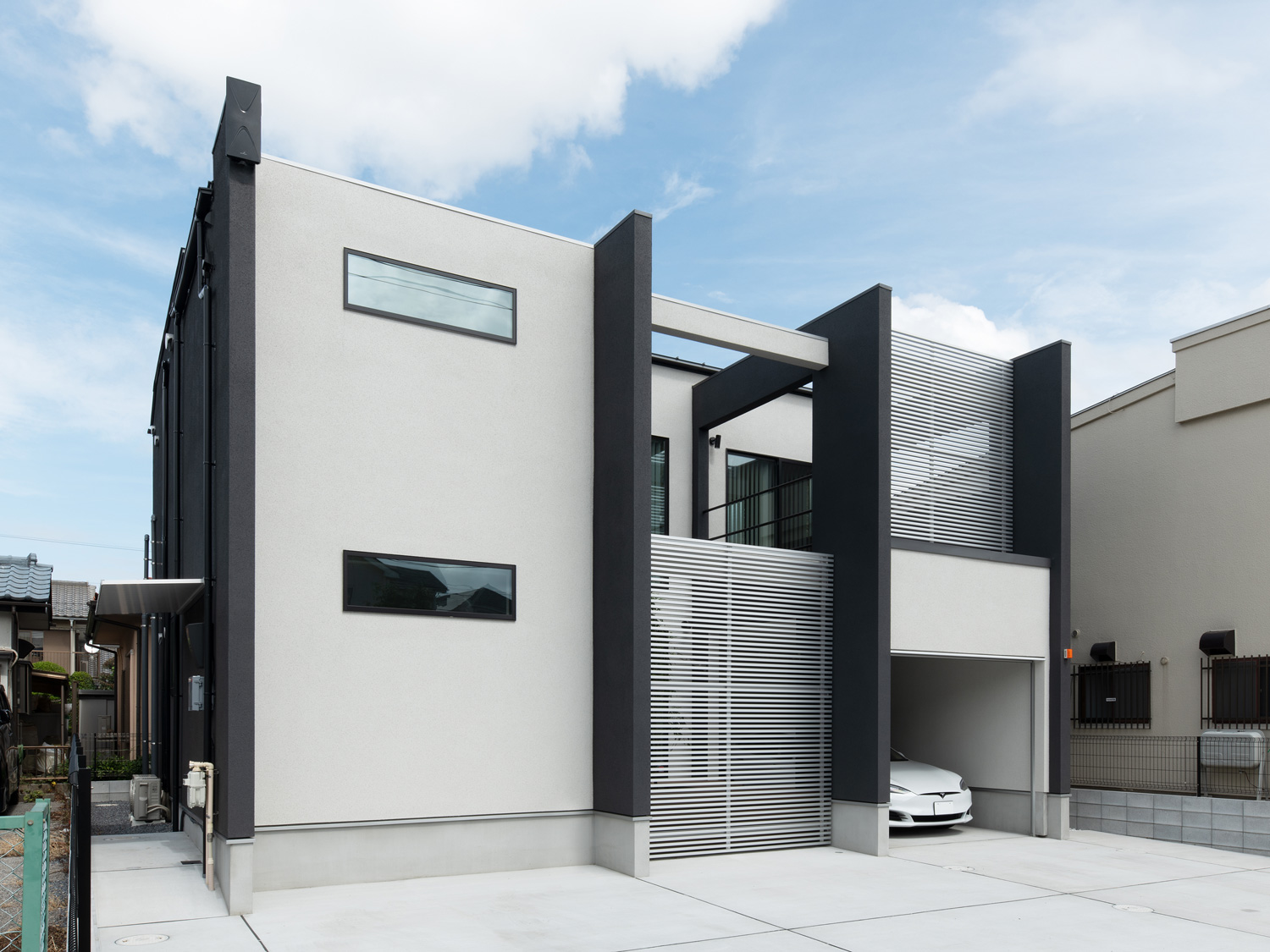 白い外壁にスリット窓が設けられた、インナーガレージのある住まい・デザイン住宅 注文住宅・デザイン住宅建築実例_『CASE639 Wall Side』_外観
