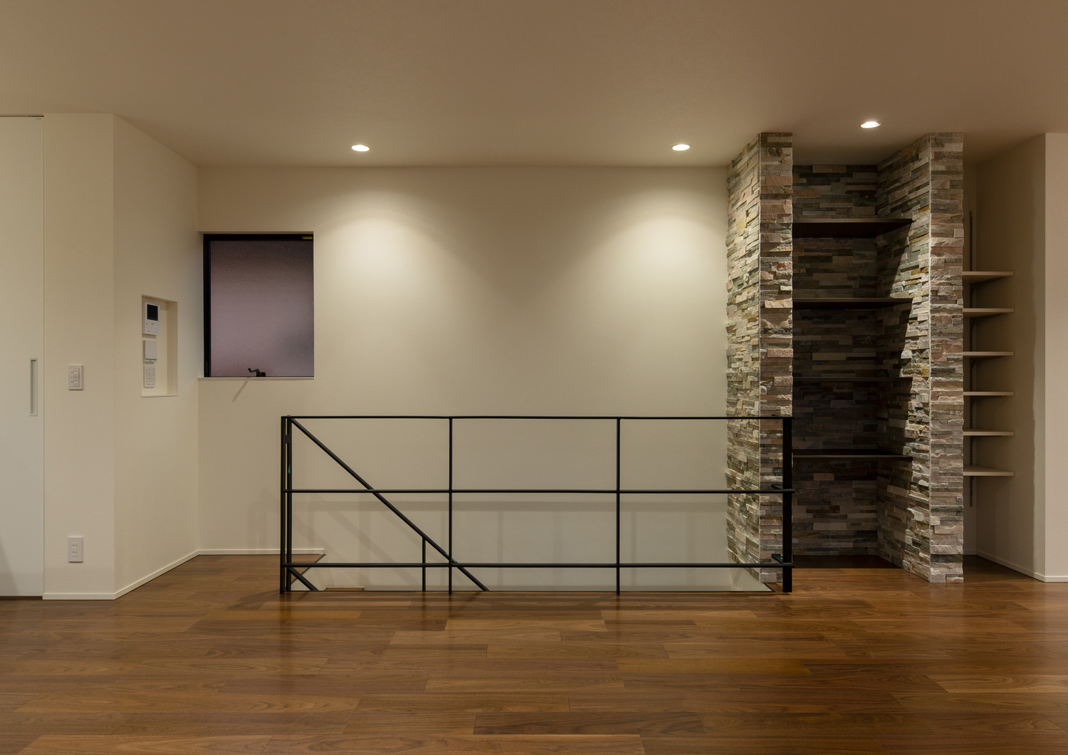 アイアンの手すりを設けた階段のそばに、タイルの壁に囲まれた壁付け棚があるLDK・デザイン住宅 注文住宅・デザイン住宅建築実例_『CASE639 Wall Side』_LDK