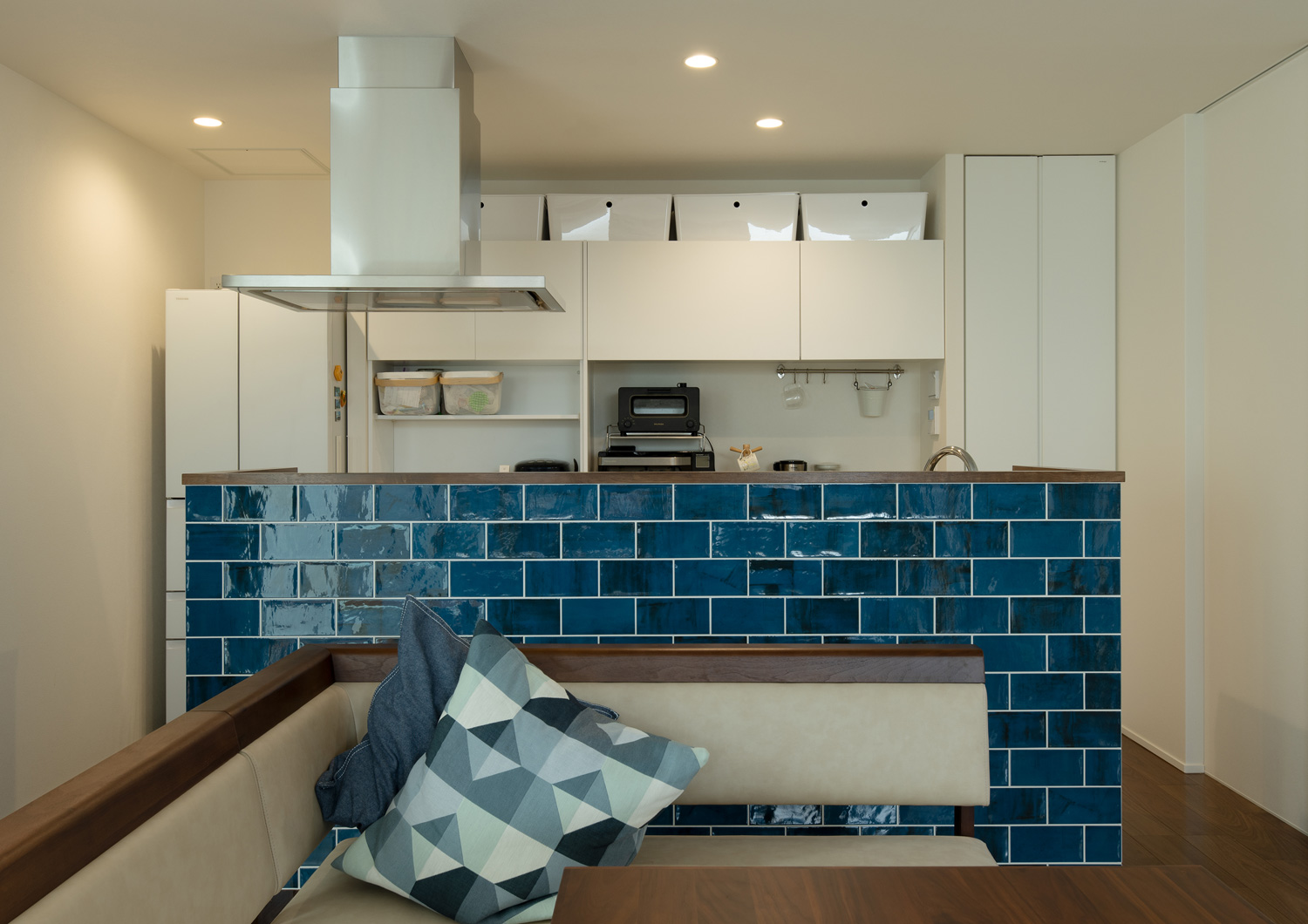 正面にダイニングテーブルがある、青いタイルの腰壁があるアイランドキッチン・デザイン住宅 注文住宅・デザイン住宅建築実例_『CASE639 Wall Side』_キッチン