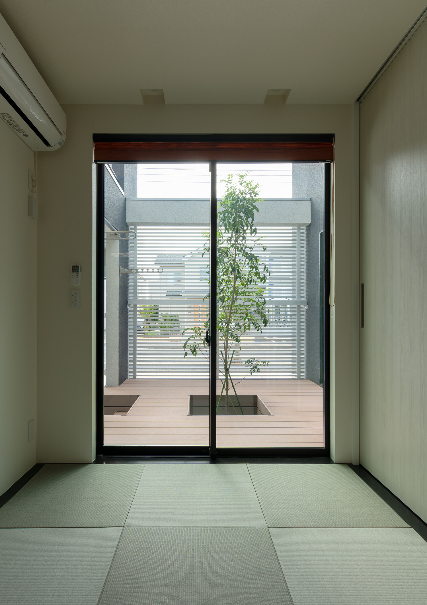 窓からシンボルツリーのあるウッドデッキの中庭が見える琉球畳の和室・デザイン住宅 注文住宅・デザイン住宅建築実例_『CASE639 Wall Side』_和室