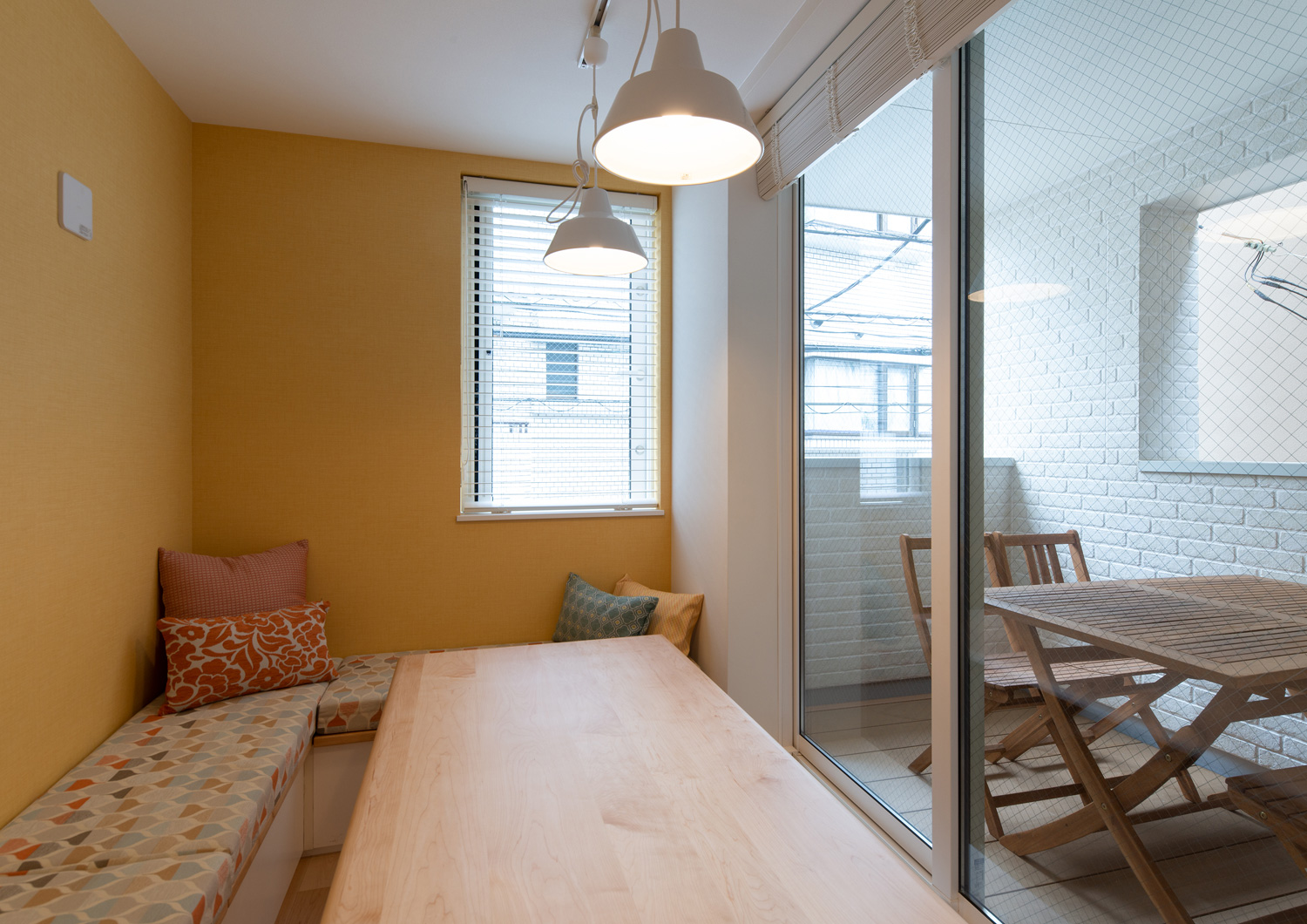 造作ベンチのある部屋から、木の椅子とテーブルが置かれたベランダが見える様子・デザイン住宅 注文住宅・デザイン住宅建築実例_『CASE641 だんだん』_LDK