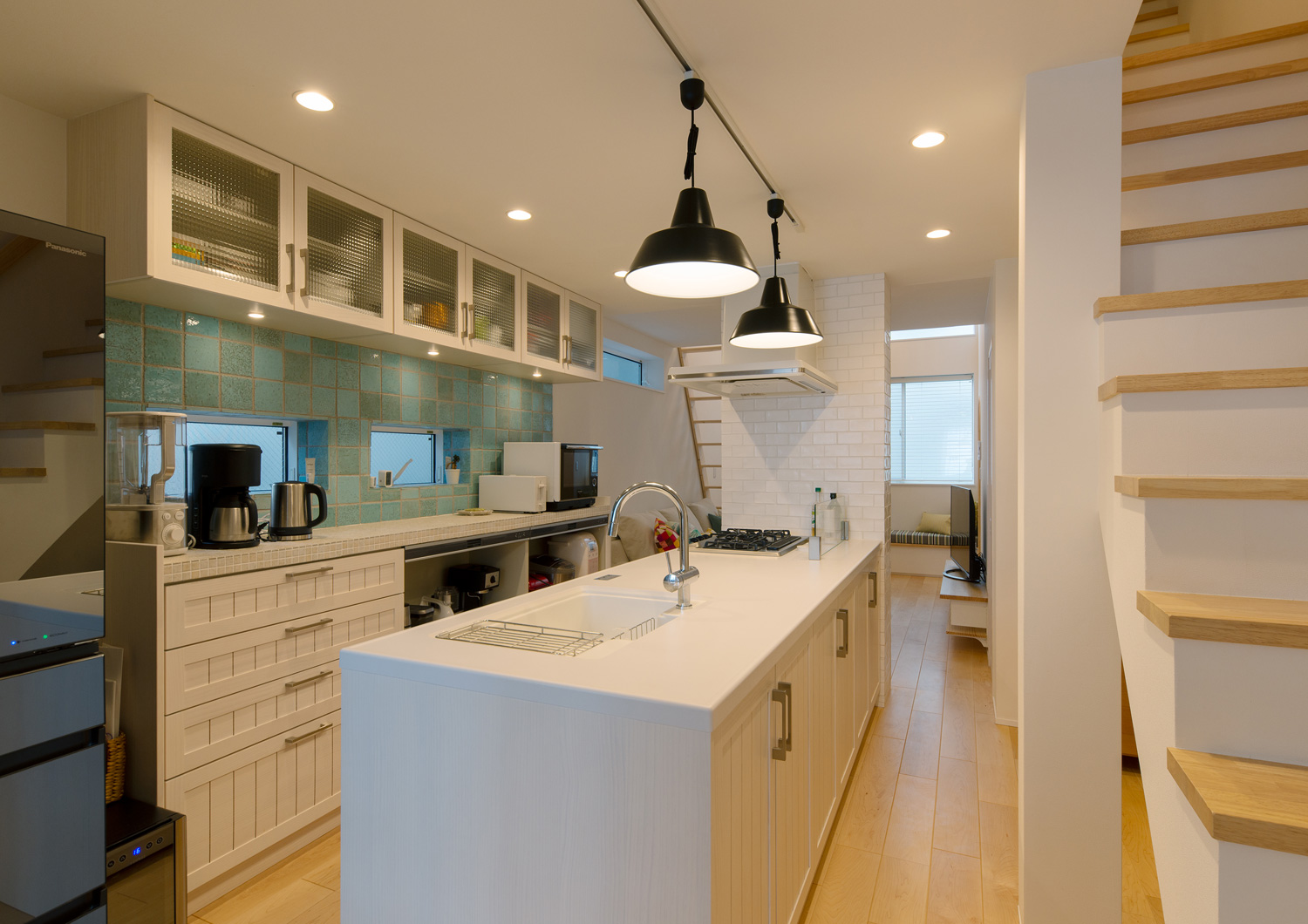 背面のカップボードの壁が青いタイルになった、白いペニンシュラキッチン・デザイン住宅 注文住宅・デザイン住宅建築実例_『CASE641 だんだん』_LDK