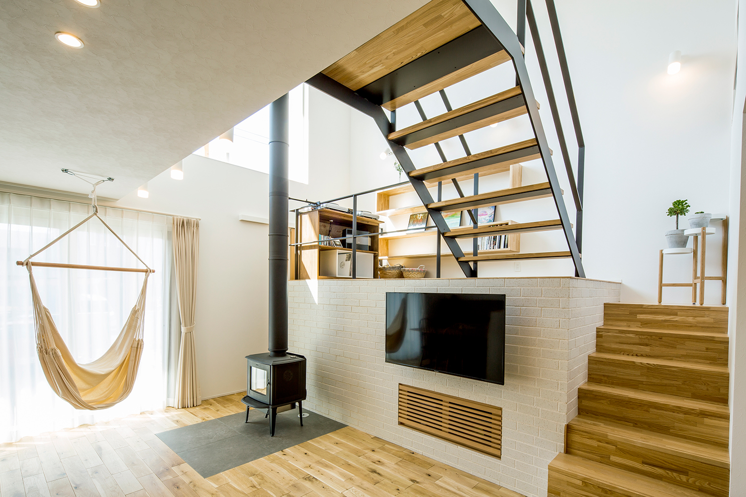 窓際にハンモックが掛けられたスキップフロアのあるLDK・デザイン住宅 注文住宅・デザイン住宅建築実例_『CASE635 三角屋根でつながる家』_LDK