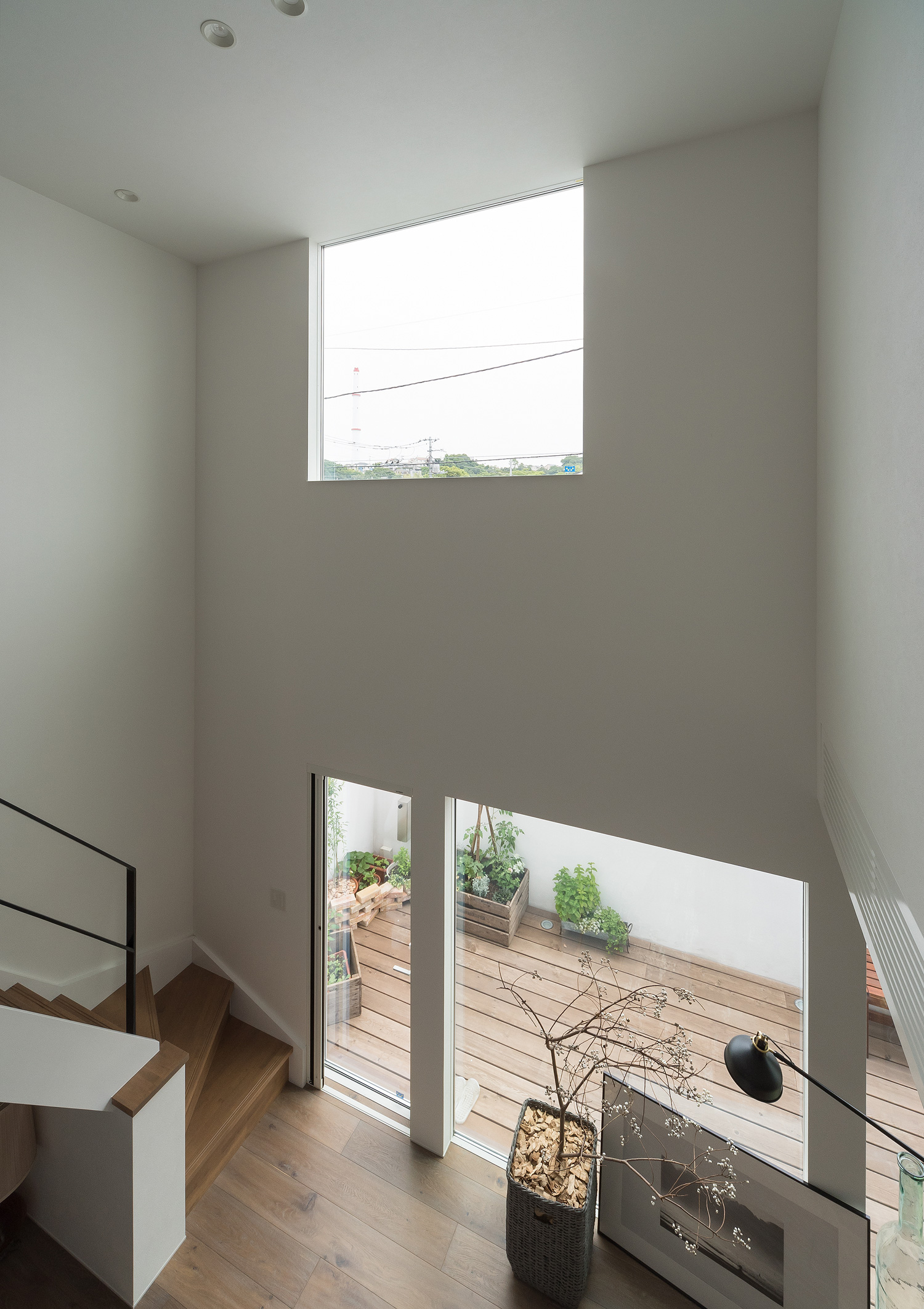 吹き抜けに面した二階の廊下からLDKやテラスを見下ろした様子・デザイン住宅 注文住宅・デザイン住宅建築実例_『CASE642 優×和』_LDK