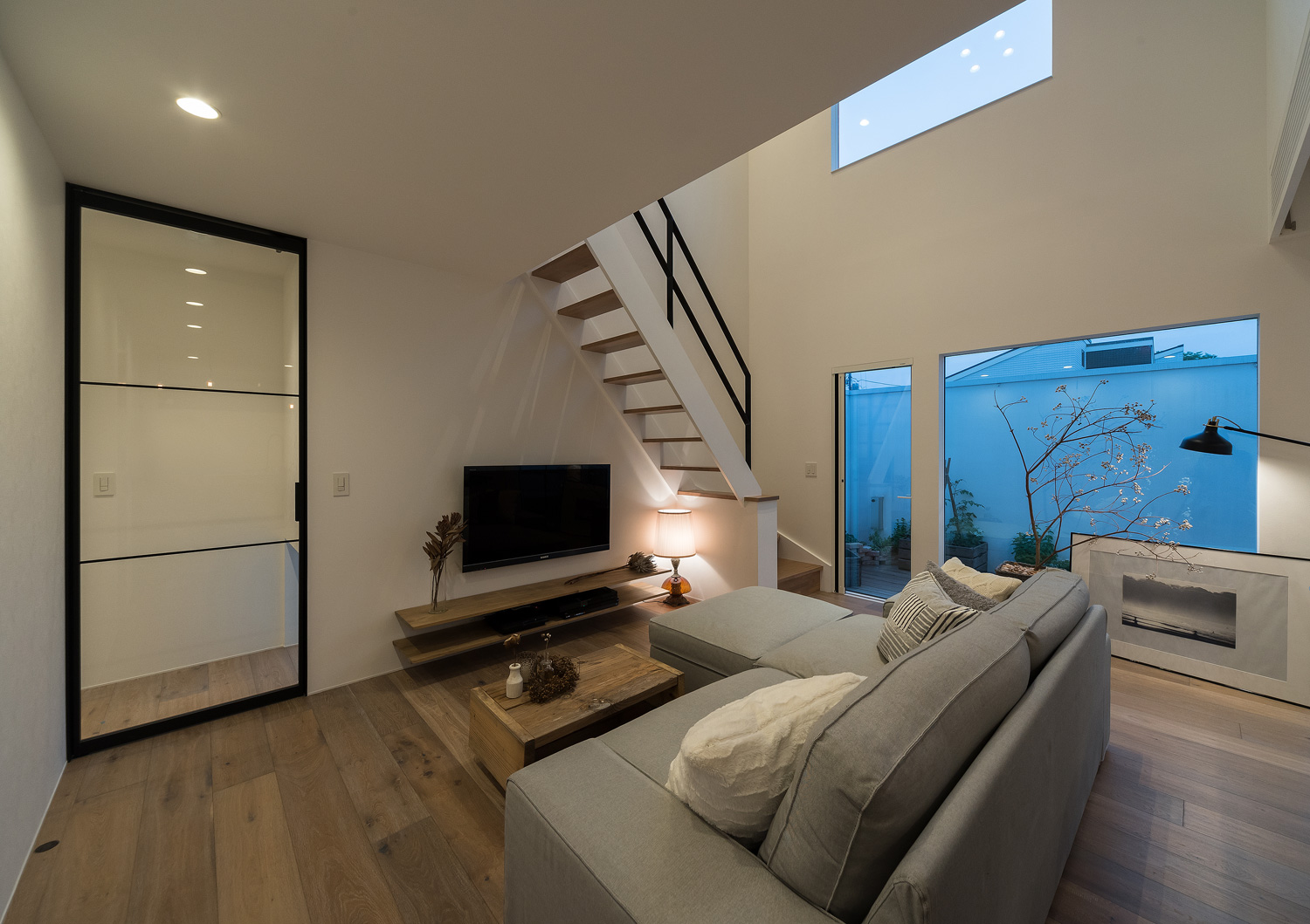 テレビのそばに間接照明を置いた、ガラス扉のあるLDK・デザイン住宅 注文住宅・デザイン住宅建築実例_『CASE642 優×和』_LDK