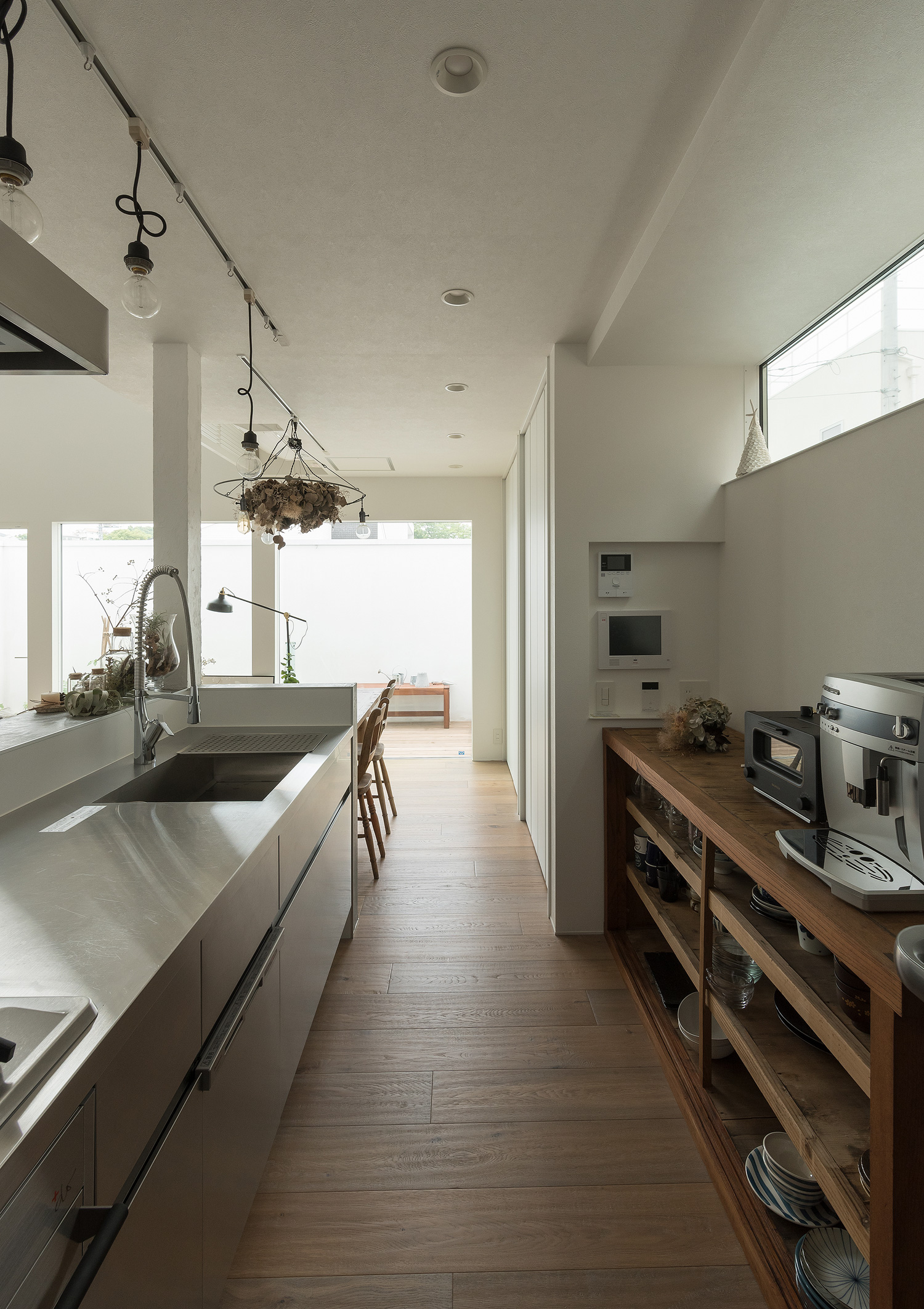 背面に木製のカップボードやスリット窓があるステンレスのペニンシュラキッチン・デザイン住宅 注文住宅・デザイン住宅建築実例_『CASE642 優×和』_キッチン