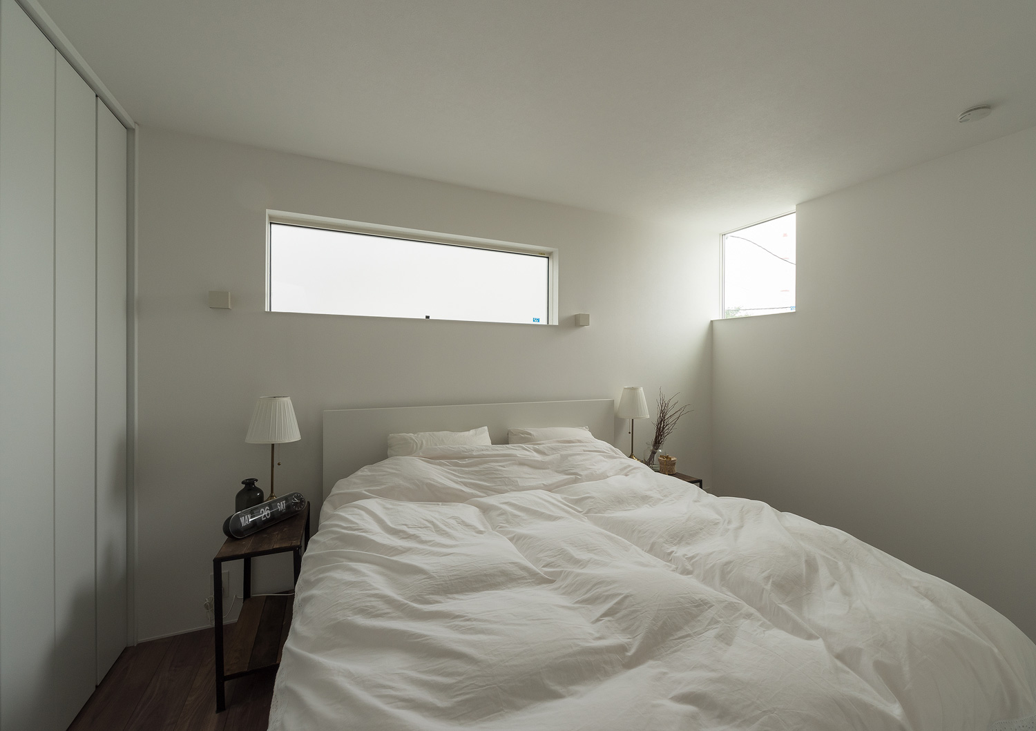 スリット窓と小さな窓がどちらもある、白いベッドのある寝室・デザイン住宅 注文住宅・デザイン住宅建築実例_『CASE642 優×和』_寝室