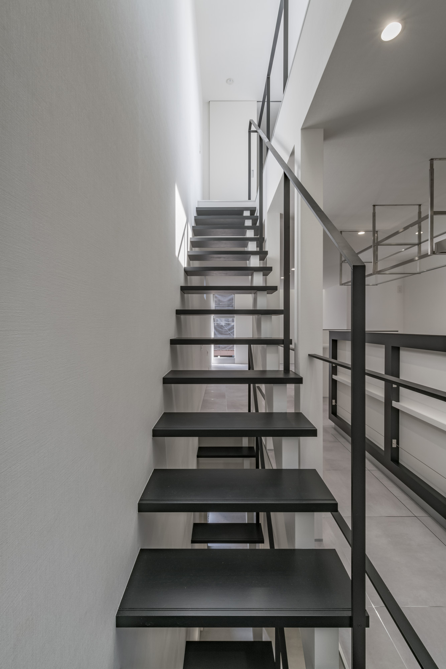 白い壁に付けられた黒い手すりがついた黒いスケルトン階段・デザイン住宅 注文住宅・デザイン住宅建築実例_『CASE646 鏡の家』_階段