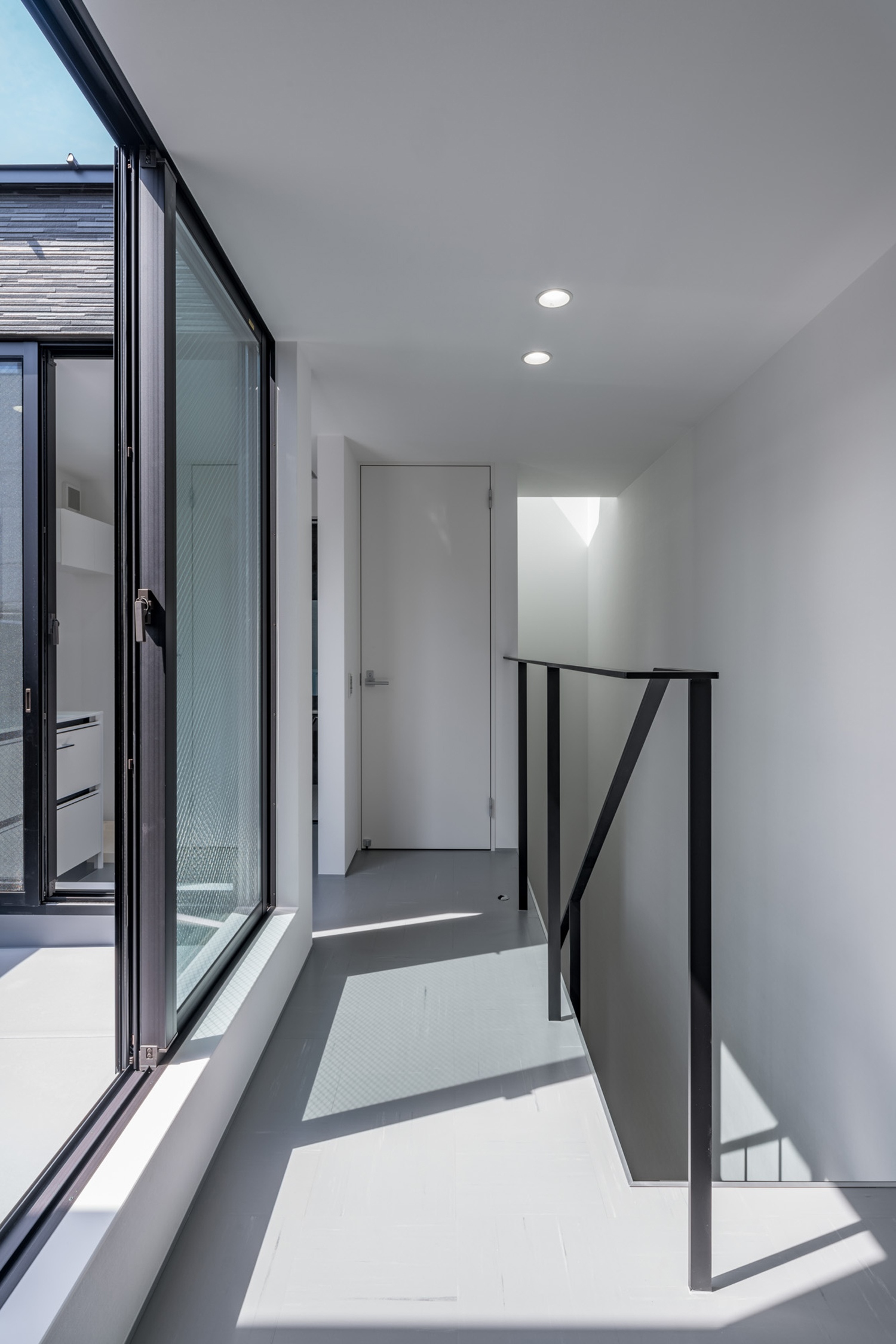 バルコニーに繋がる窓がある廊下・デザイン住宅 注文住宅・デザイン住宅建築実例_『CASE646 鏡の家』_階段