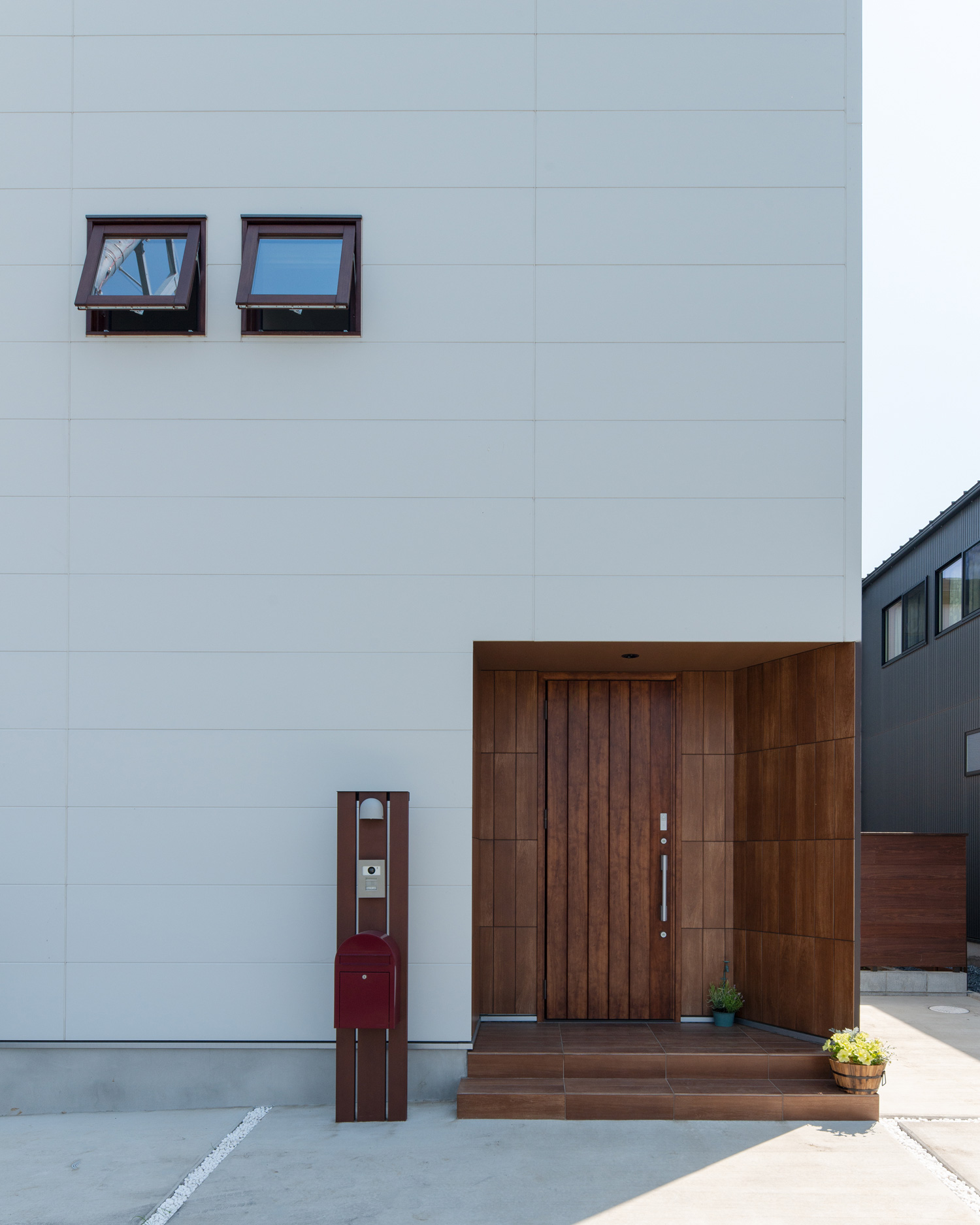 小さな窓が二つならんだ、木の玄関ポーチがある住宅・デザイン住宅 注文住宅・デザイン住宅建築実例_『CASE647 ニコニコハウス』_外観