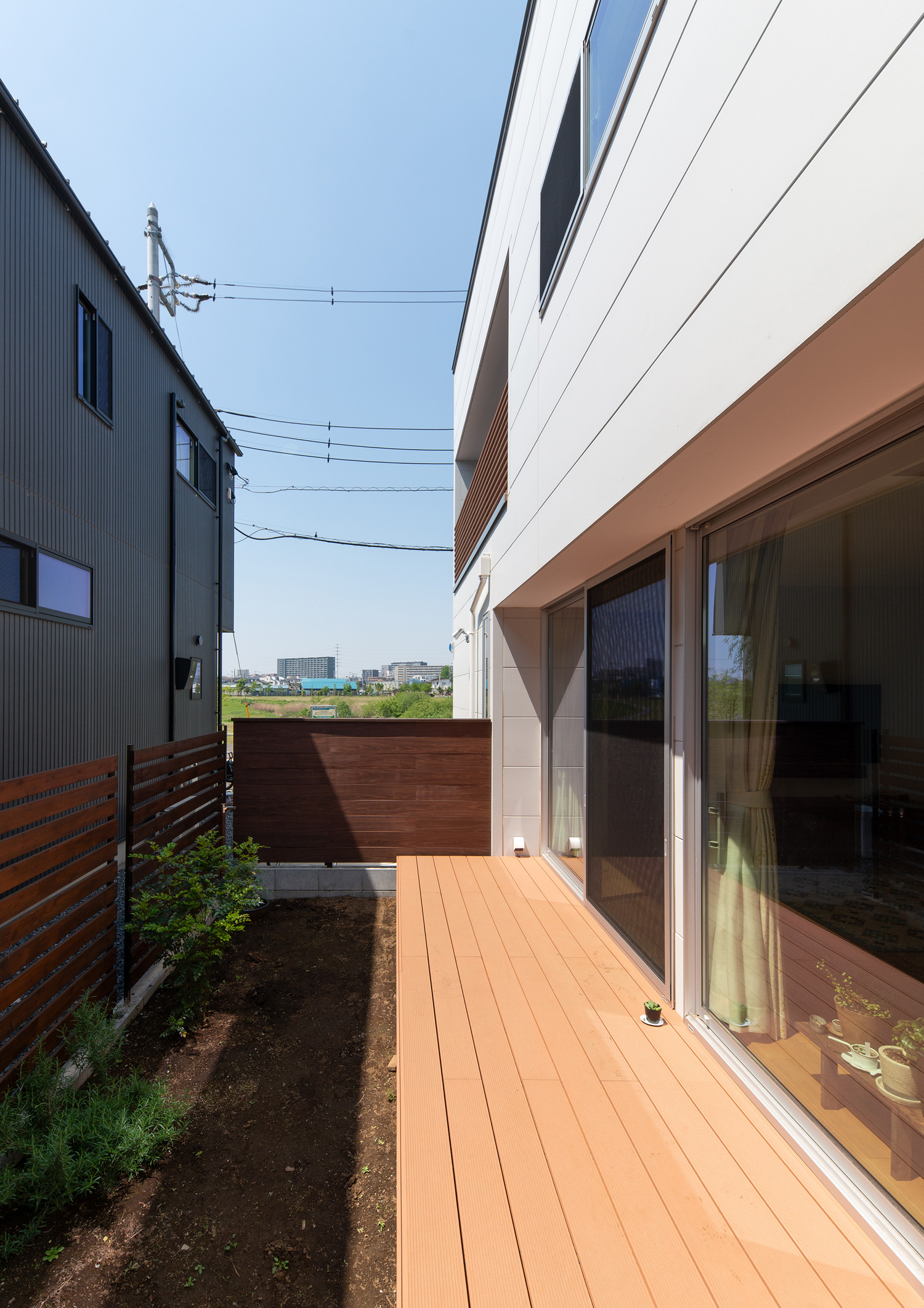 木製の目隠しで囲まれたウッドデッキのテラス・デザイン住宅 注文住宅・デザイン住宅建築実例_『CASE647 ニコニコハウス』_テラス・バルコニー