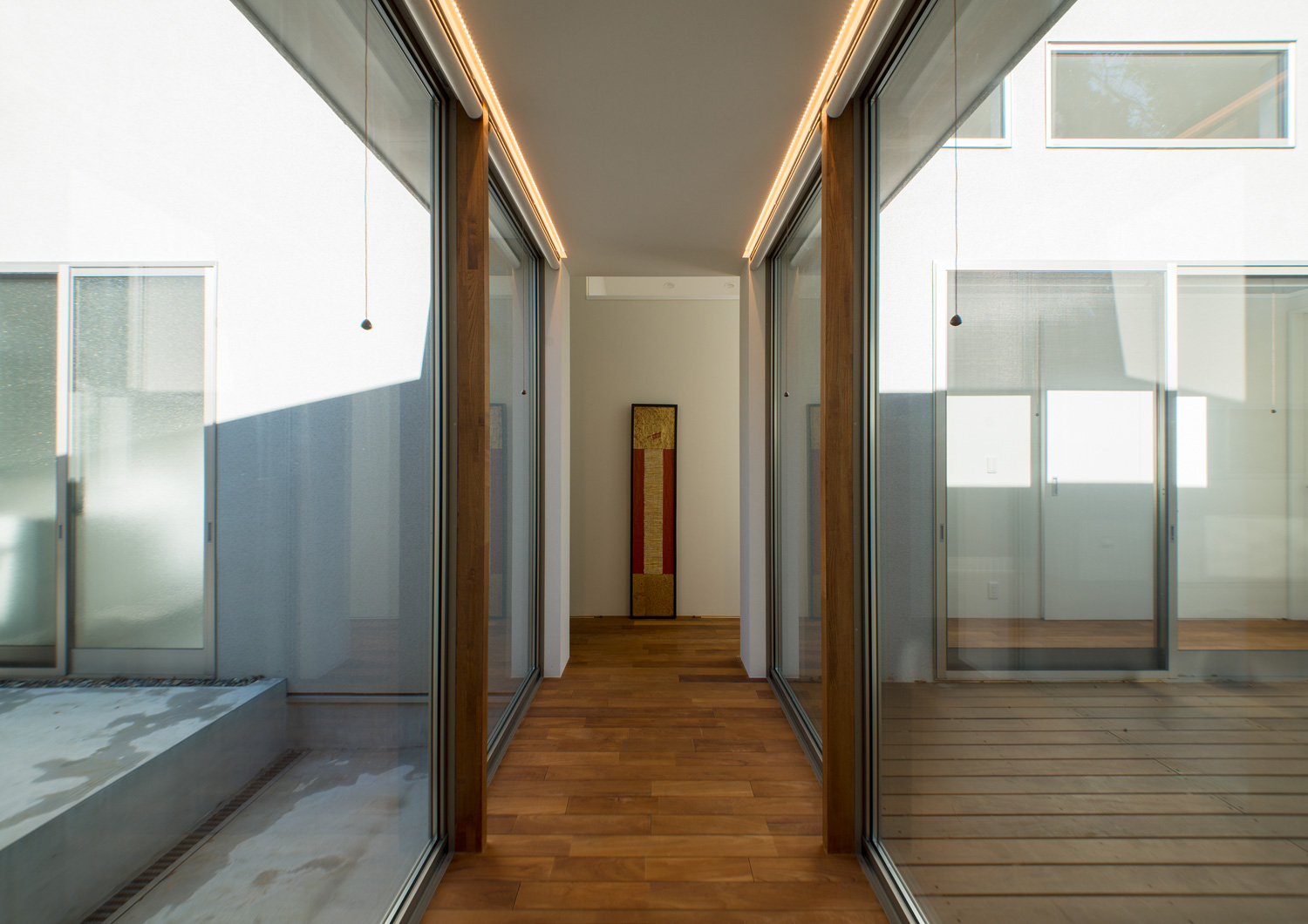 大開口窓に挟まれ、庭の様子が見えるフローリングの廊下・デザイン住宅 注文住宅・デザイン住宅建築実例_『CASE649 光の通り道』_テラス・バルコニー