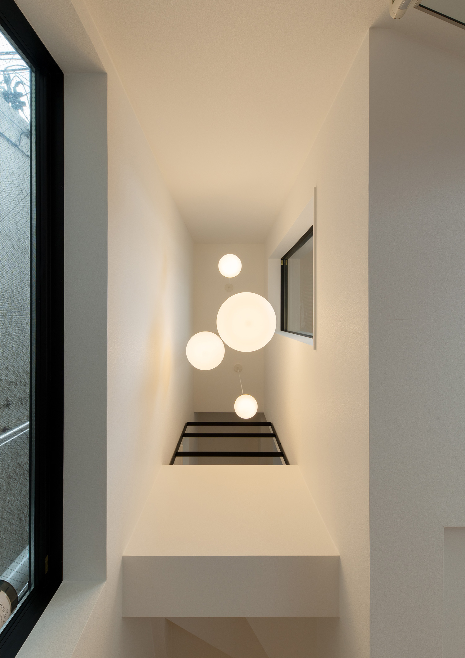 吹き抜けの天井に丸いペンダントライトが設けられた様子・デザイン住宅 注文住宅・デザイン住宅建築実例_『CASE651 New_tral House』_玄関