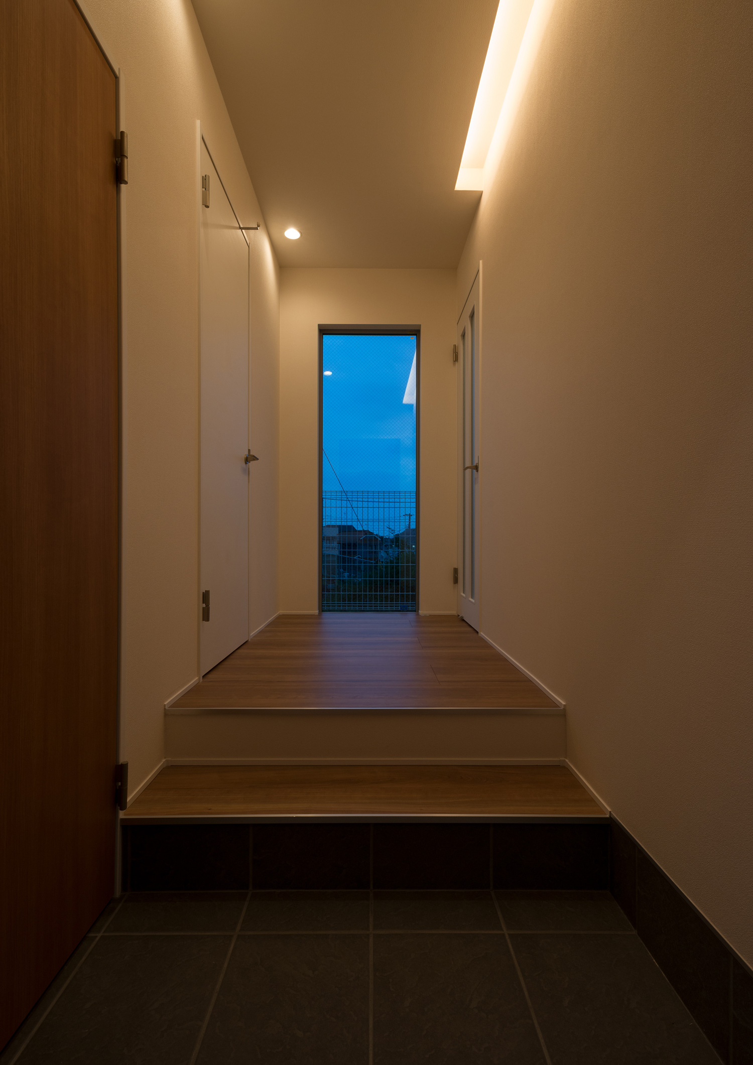 壁際に間接照明が取り付けられた、突き当りに窓がある廊下・デザイン住宅 注文住宅・デザイン住宅建築実例_『CASE650 景色を持つ家』_玄関