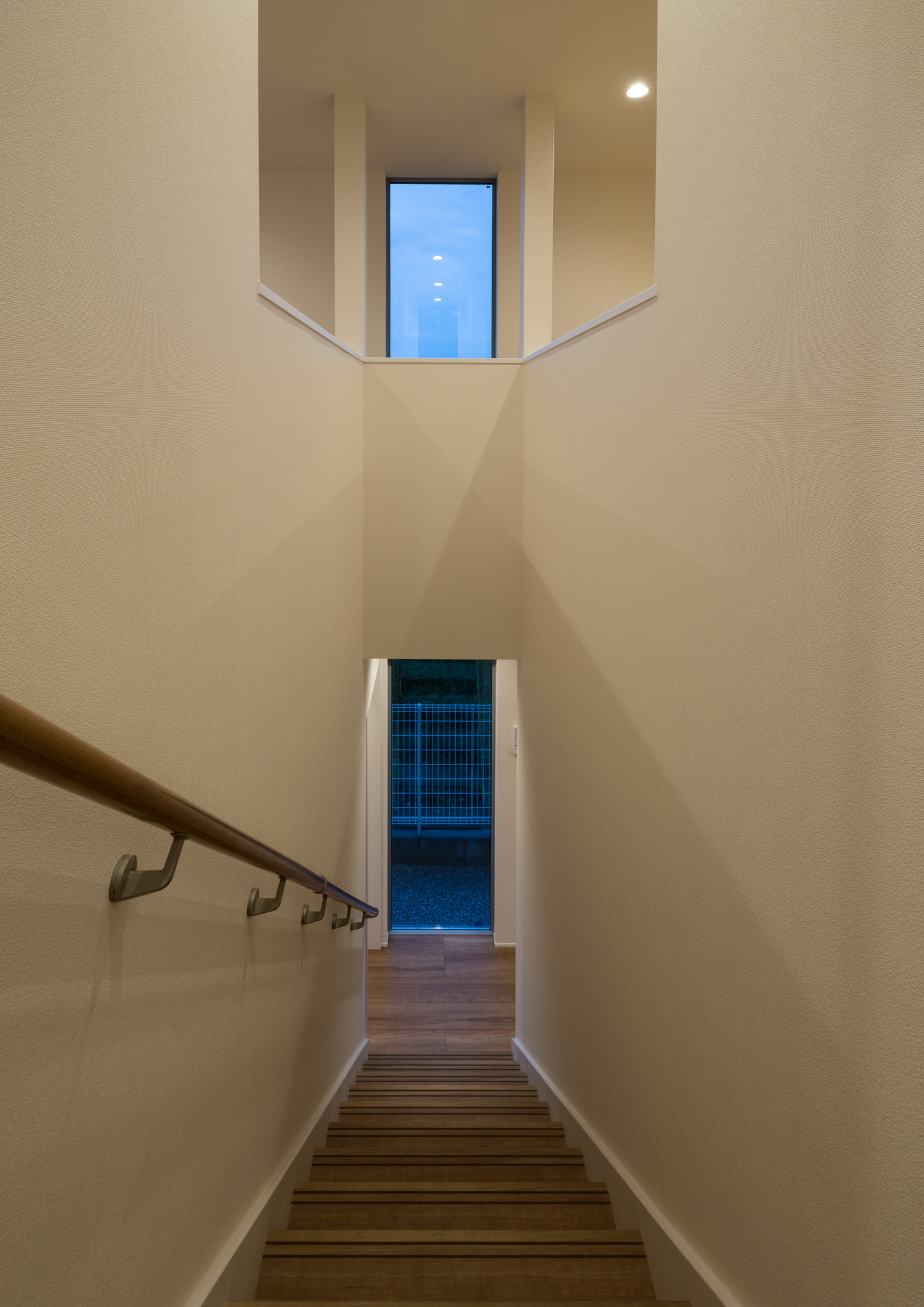 正面に窓がある白い壁に囲まれた木製の階段・デザイン住宅 注文住宅・デザイン住宅建築実例_『CASE650 景色を持つ家』_階段