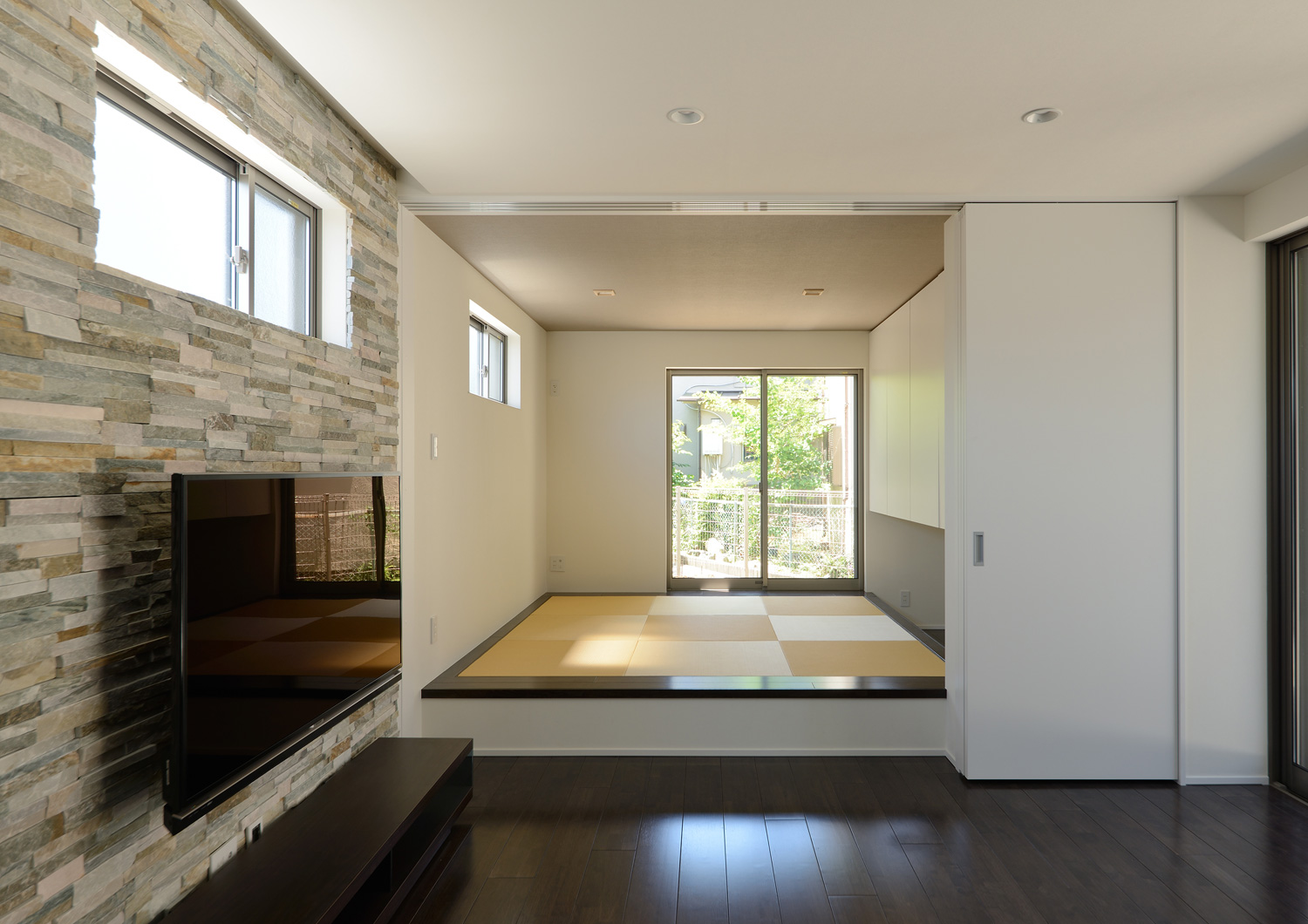 小上がりになった和室スペースの窓から植栽が見える様子・デザイン住宅 注文住宅・デザイン住宅建築実例_『CASE652 2つの吹抜けを持つ家。』_LDK