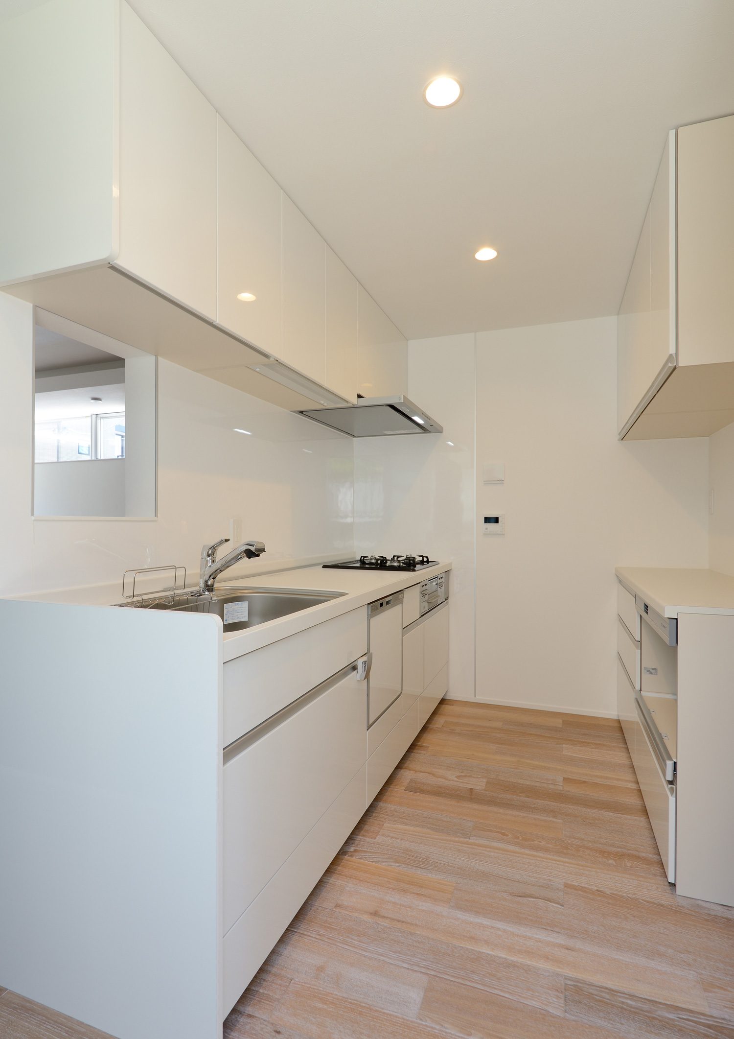 シンクの前にリビングが見渡せる小窓を設けた白い壁付きのキッチン・デザイン住宅 注文住宅・デザイン住宅建築実例_『CASE654 circulating』_キッチン