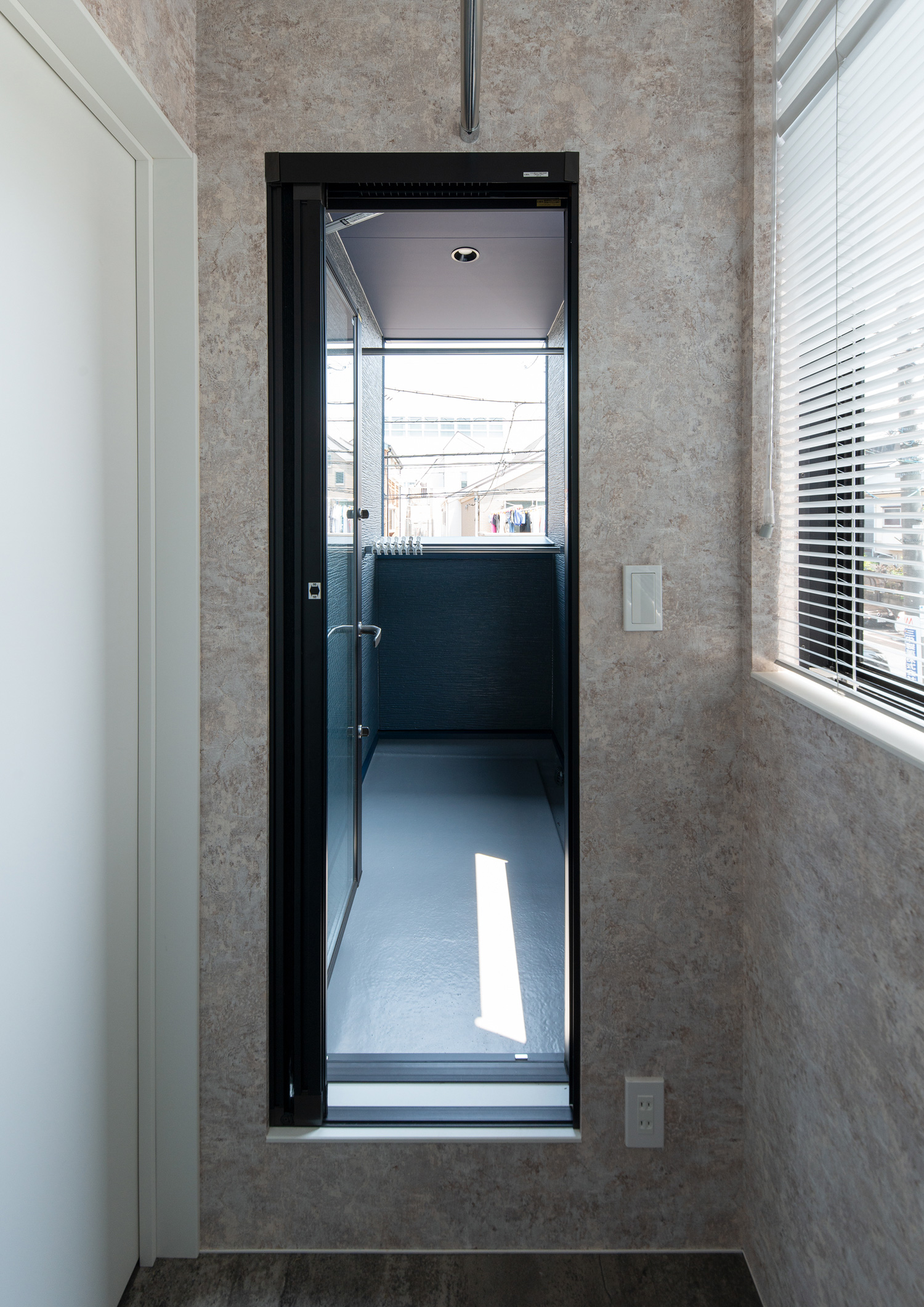 廊下の突き当りに、ベランダに出ることが出来る窓がある様子・デザイン住宅 注文住宅・デザイン住宅建築実例_『CASE655 群青』_テラス・バルコニー