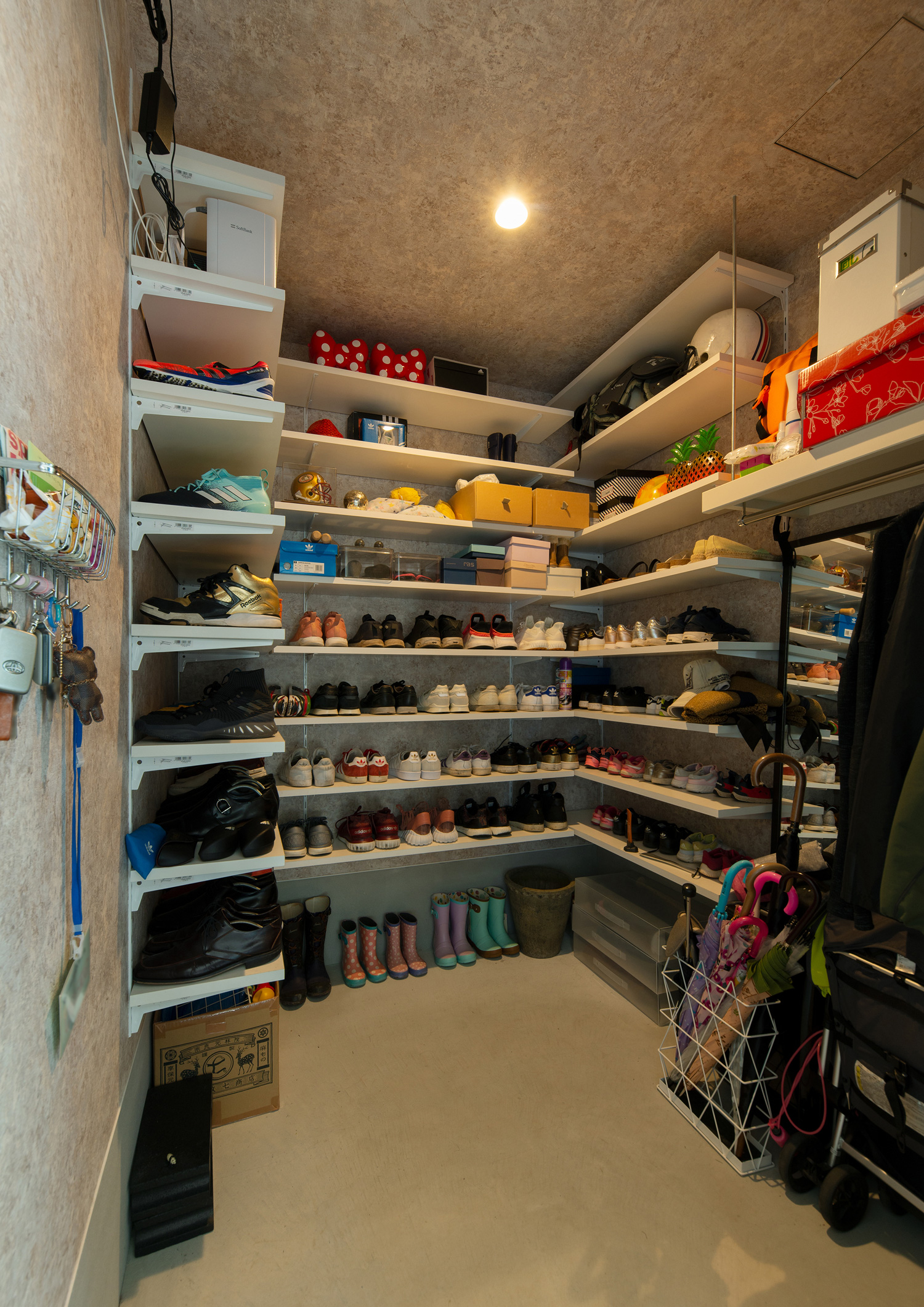 壁一面に棚が取り付けられており、靴や傘などが収納されたシューズインクローゼット・デザイン住宅 注文住宅・デザイン住宅建築実例_『CASE655 群青』_玄関